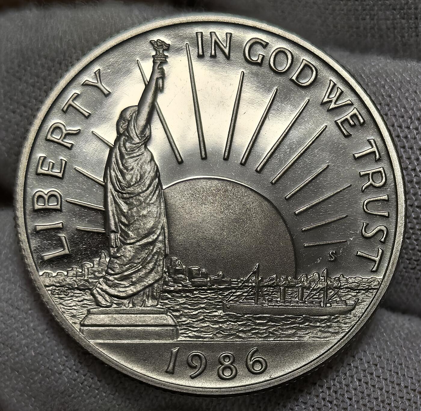 外国优质银币非洲美洲币，周六九点倒数截拍，满百包邮，持续收拍 稀少精制币美国1986 年移民主题精制半元，正面绘自由女神像，背面展移民登岸场景，题材呼应 “移民之国” 定位，精制币细节饱满，具人文纪念与收藏价值。