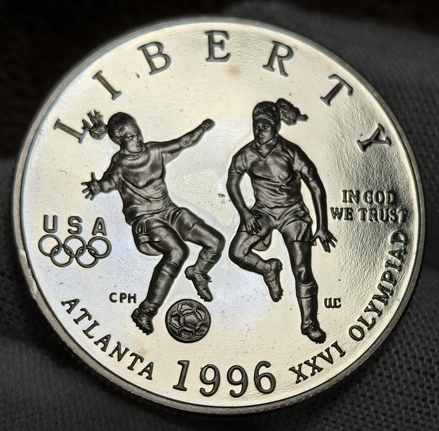 外国优质银币非洲美洲币，周六九点倒数截拍，满百包邮，持续收拍 稀少精制币美国1996 年亚特兰大奥运半元，正面绘女足运动员竞技场景，背面展奥运火炬与五环，题材关联百年奥运，精制币细节生动，具体育纪念与收藏价值。
