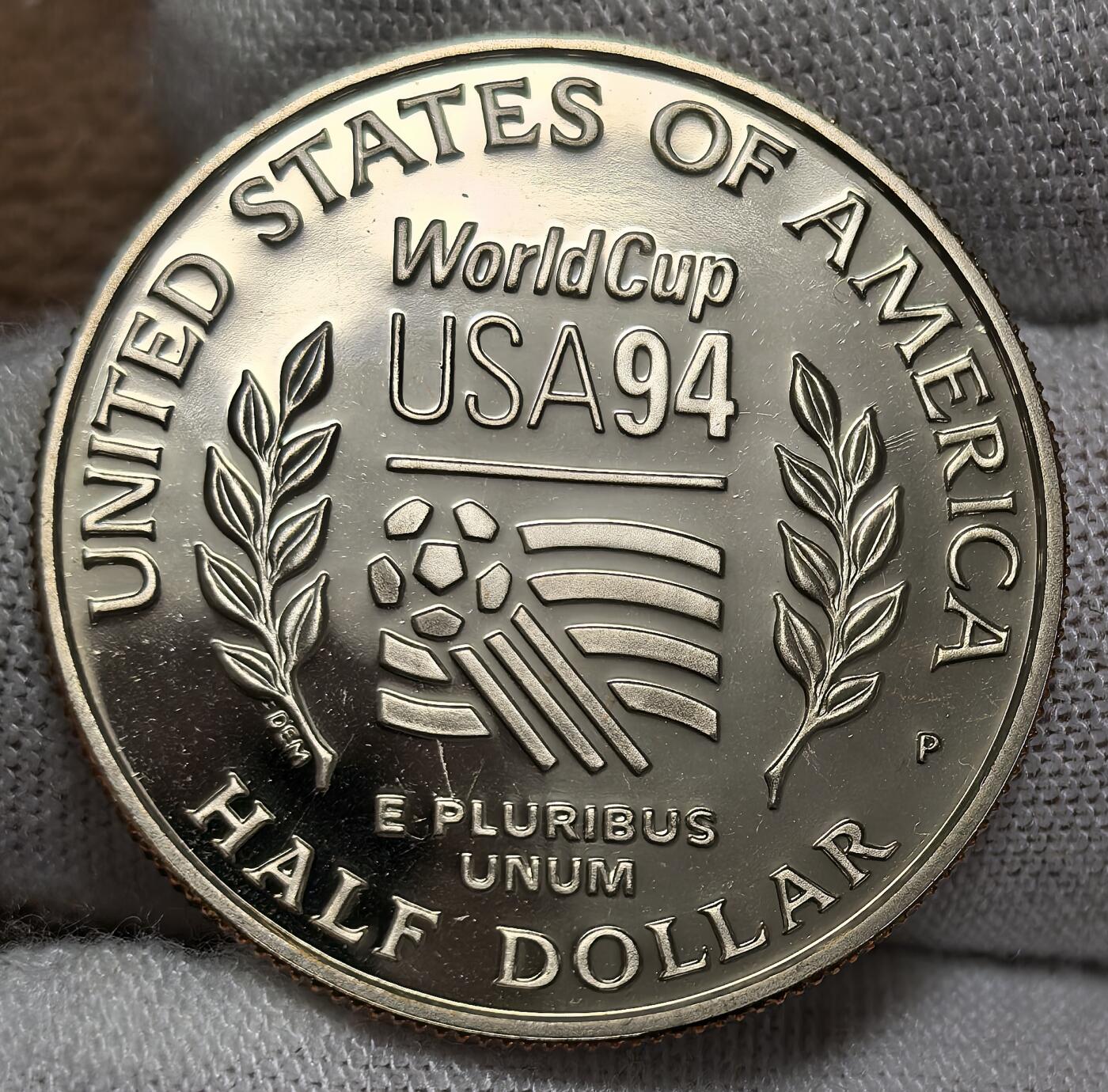 外国优质银币非洲美洲币，周六九点倒数截拍，满百包邮，持续收拍 美国1994 年世界杯精制半元纪念币，正面绘足球运动员身姿，背面标 “USA94” 赛事标识，题材关联顶级体育赛事，精制币工艺细腻，具体育纪念与收藏价值。