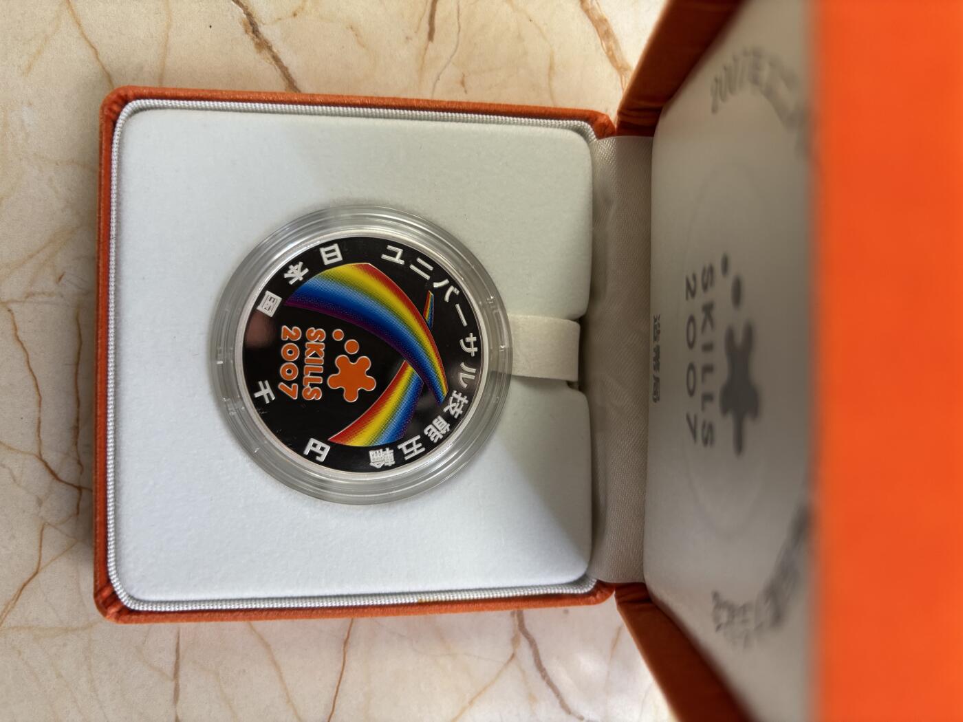 第187期拍卖 日本2007年1千日元精制彩色银币 国际技能节 31.1克 999银，银价373，发行量：8万枚