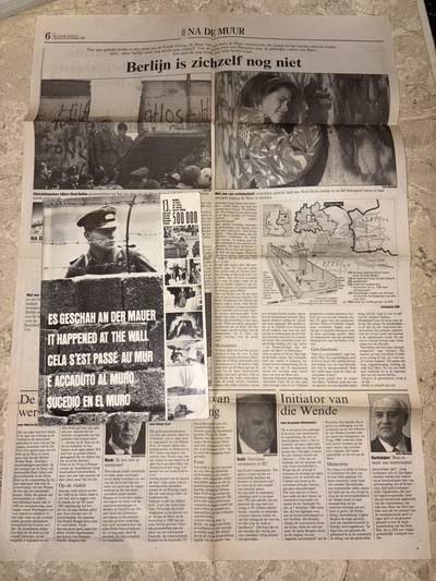 盛世勋华——号角文化勋章邮票专场拍卖第298期 - 德国柏林墙文献《发生在墙边的事》，附带荷兰语报纸对柏林墙相关历史的专题报道，记录了1961年8月13日柏林墙修建至1989年倒塌期间，西柏林周边封锁带的发展与关键事件。全书127页，采用黑白纪实摄影，左侧是守卫柏林墙的士兵形象，右侧是柏林墙相关事件的纪实小图（如越墙尝试、热气球逃亡、地标建筑等），直观展现冷战时期柏林的分裂状态。