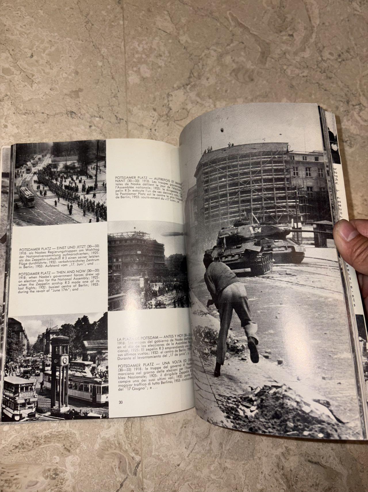 盛世勋华——号角文化勋章邮票专场拍卖第298期 德国柏林墙文献《发生在墙边的事》，附带荷兰语报纸对柏林墙相关历史的专题报道，记录了1961年8月13日柏林墙修建至1989年倒塌期间，西柏林周边封锁带的发展与关键事件。全书127页，采用黑白纪实摄影，左侧是守卫柏林墙的士兵形象，右侧是柏林墙相关事件的纪实小图（如越墙尝试、热气球逃亡、地标建筑等），直观展现冷战时期柏林的分裂状态。