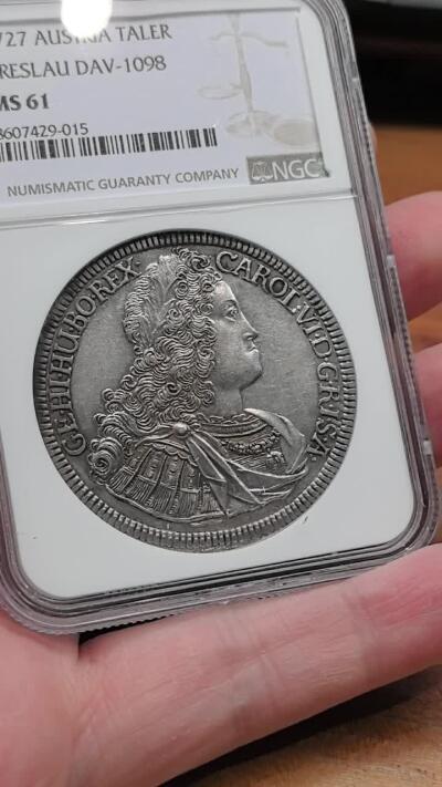 凡希社世界钱币微拍第三百十八期 荐！1727神罗哈布斯堡王朝卡尔六世戎装像泰勒大银NGC-MS61，铁灰色包浆，注意正面的卷发和月桂冠细节。1727年正值卡尔六世推动《国本诏书》确立哈布斯堡家族继承规则的关键时期，此币是神圣罗马帝国中期货币体系的重要实物，布雷斯劳铸币厂版本少于维也纳铸币厂版本，它直观地反映了帝国东部领地的铸币权分布。（视频参考）