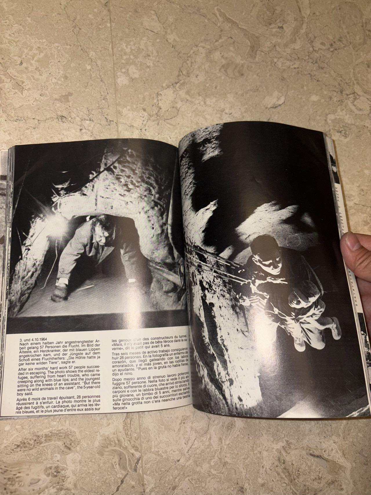 盛世勋华——号角文化勋章邮票专场拍卖第298期 德国柏林墙文献《发生在墙边的事》，附带荷兰语报纸对柏林墙相关历史的专题报道，记录了1961年8月13日柏林墙修建至1989年倒塌期间，西柏林周边封锁带的发展与关键事件。全书127页，采用黑白纪实摄影，左侧是守卫柏林墙的士兵形象，右侧是柏林墙相关事件的纪实小图（如越墙尝试、热气球逃亡、地标建筑等），直观展现冷战时期柏林的分裂状态。