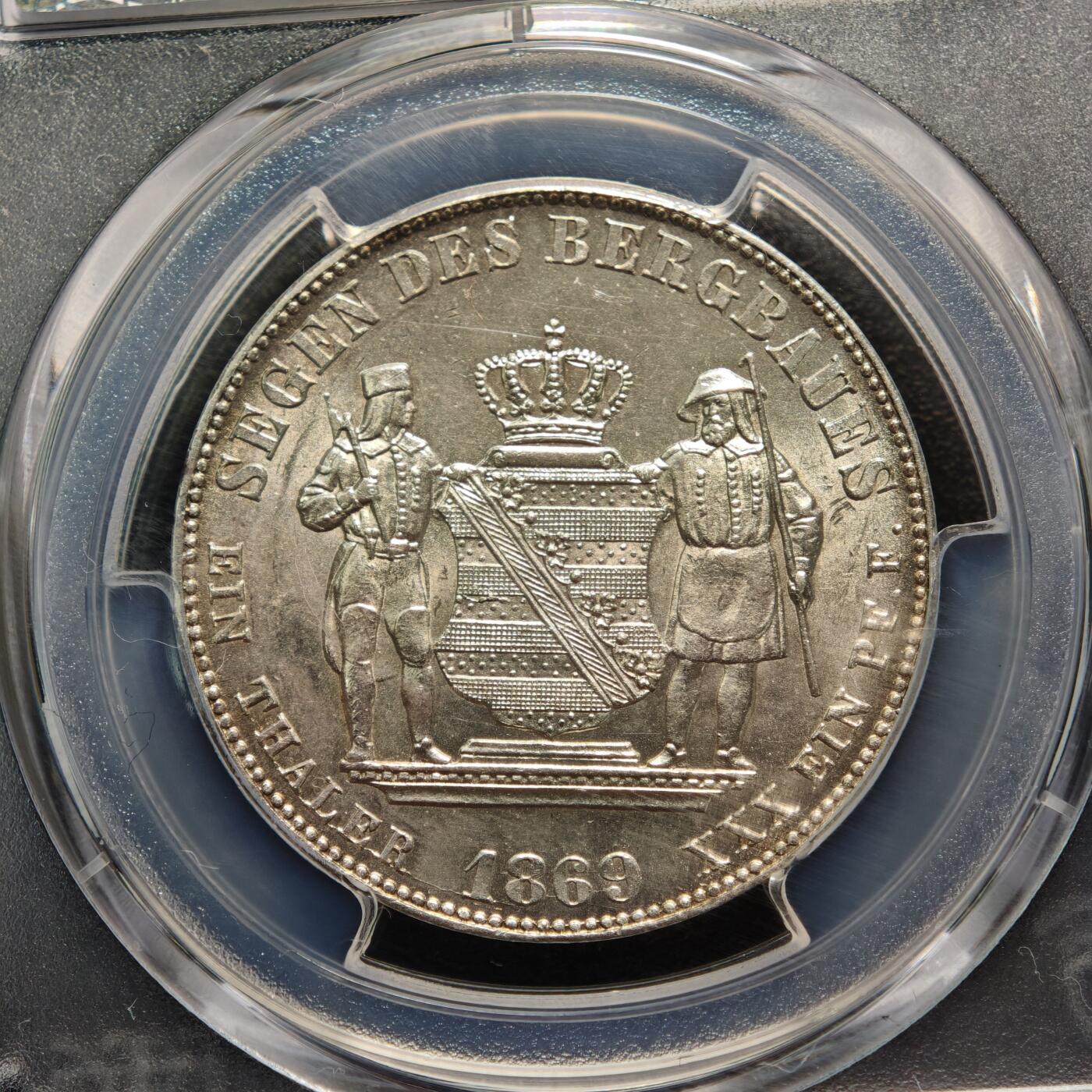 【德藏】世界币章拍卖第161期  1869年 德国萨克森约翰一世矿业祝福泰勒银币 PCGS MS62 淡黄油包浆 转光十足 萨克森是19世纪德国重要的矿业与冶金中心，银、锡、铁等矿产资源的开采与加工是其经济支柱，约翰一世时期发行此币，既是对矿业产业的致敬，也彰显了萨克森的经济特色