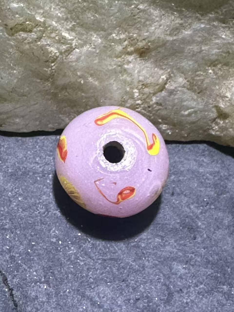 建国前后库存冰粉色祥云立体凤眼琉璃珠一颗，