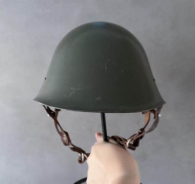 大猫徽章拍卖 第286期 罗马尼亚M73钢盔（罗马尼亚语：casca model 1973）是罗马尼亚社会主义共和国1973年列装的制式钢盔，是冷战时期罗马尼亚为摆脱苏联装备影响、彰显军事独立性的标志性装备，好品稀少带原盔罩（盔罩原始破损）头围54到58可调整。