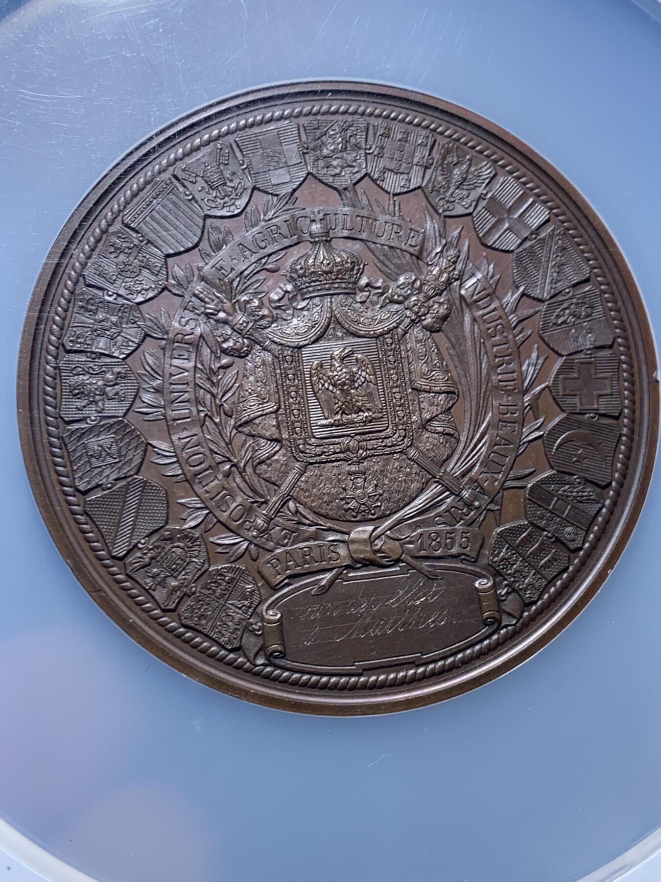 《竞宝斋》第457场 周日，周一，周二   3场连拍 （全场包邮）欢迎送拍 NGC MS64BN 法国1855年巴黎世博会纪念大铜章 60mm（签名版）定制款稀缺品，顶级高分，拿三章牌中的热门品种，20国徽章环绕波拿巴家族鹰徽，众星捧月，繁复华丽，记录拿破仑三世的巅峰时刻。手指边铭原铸品，加大加厚盒装。