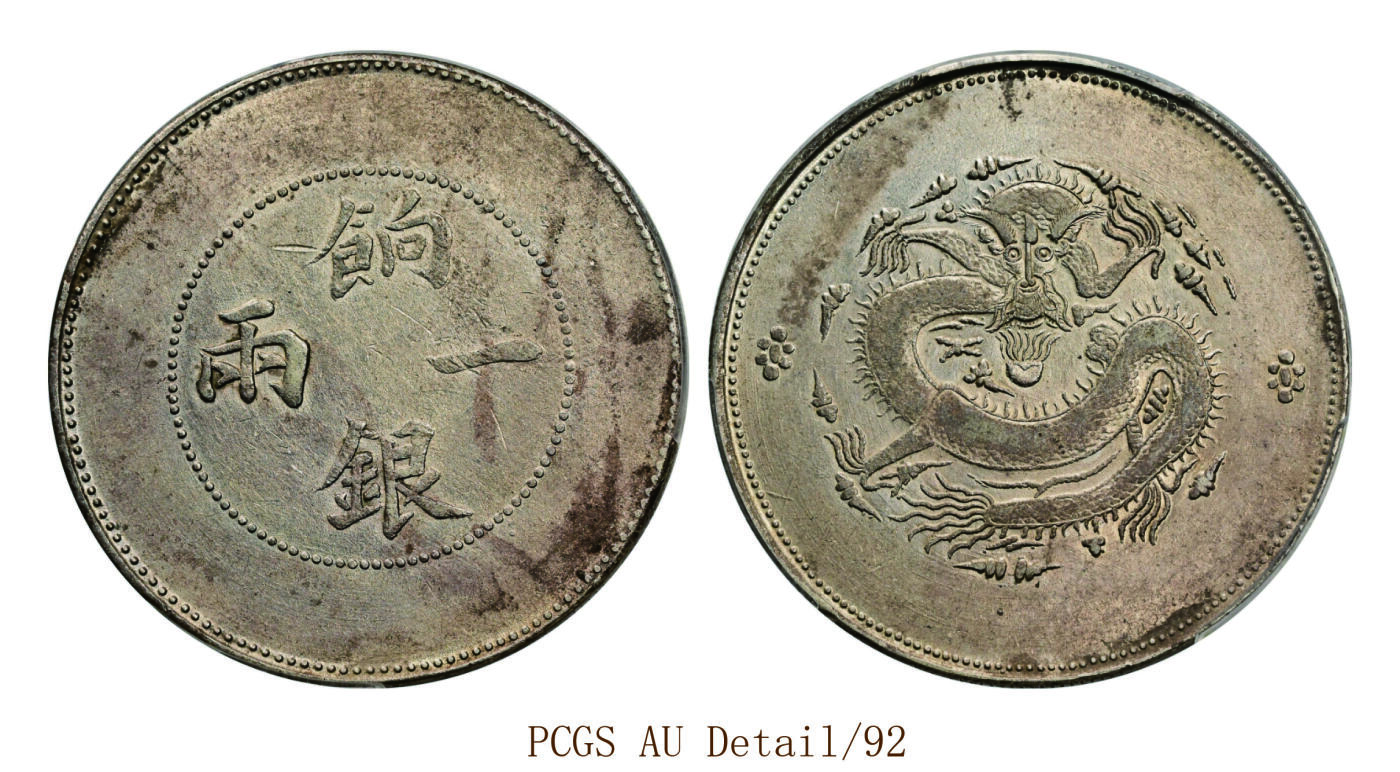 宜和2025年秋季拍卖 古钱/金银锭/机制币 清代 新疆饷银一两银币一枚，无回文版，背逆、龙鳞清晰，色泽亮润，品相极佳；PCGS AU Detail/92，编号89492736 Y-7/LM-811