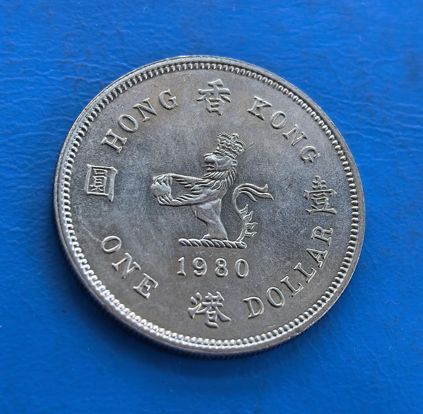 外国优质银币南亚香港苏联等专场，周六九点倒数截拍，满百包邮，持续收拍 原光1980年香港壹圆，正面为英女王伊丽莎白二世侧面像，环刻 “QUEEN ELIZABETH THE SECOND” 字样；背面是戴皇冠的狮子图案，搭配 “香港 壹圆” 字样与英文 “ONE DOLLAR”。原光包浆保留出厂光泽，见证英属香港末期货币历史，是近代殖民钱币收藏的优质品类。