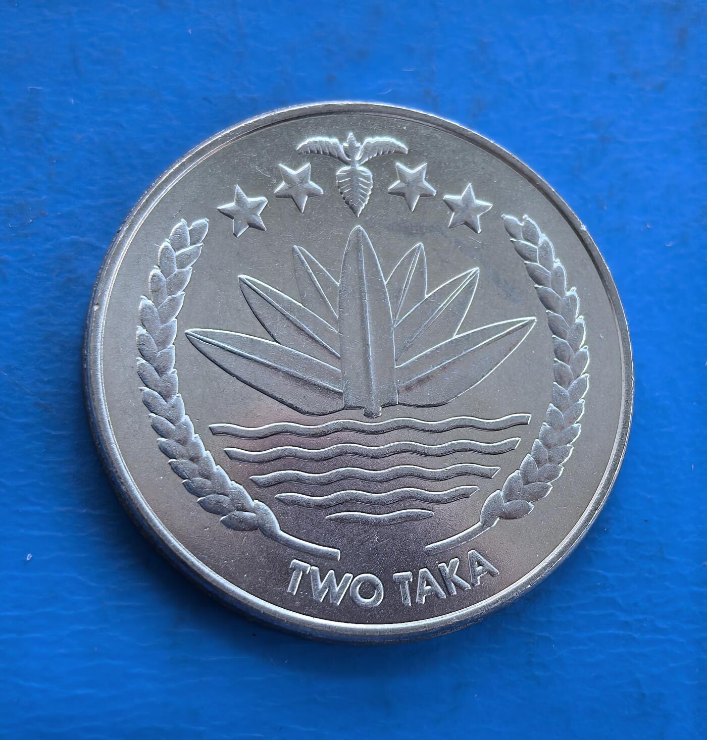 外国优质银币南亚香港苏联等专场，周六九点倒数截拍，满百包邮，持续收拍 孟加拉国2013 年 2 塔卡流通纪念币，正面是国家领导人谢赫・穆吉布・拉赫曼的肖像，辅以孟加拉语铭文与年份标识；背面是国徽图案，水纹上的莲花搭配星星、飞鸟与麦穗，象征国家的农业根基与和平愿景，金属质感细腻，兼具历史纪念与收藏价值