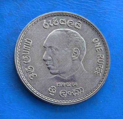 外国优质银币南亚香港苏联等专场，周六九点倒数截拍，满百包邮，持续收拍 - 斯里兰卡1978 年1 卢比纪念币，正面是前总统朱尼厄斯・理查德・贾亚瓦德纳的侧面像，辅以僧伽罗语、泰米尔语、英语三种文字，设计多元；背面是斯里兰卡国徽，展现佛教文化与国家象征，温润包浆沉淀着时代底蕴，是兼具历史意义与特色的收藏币种。