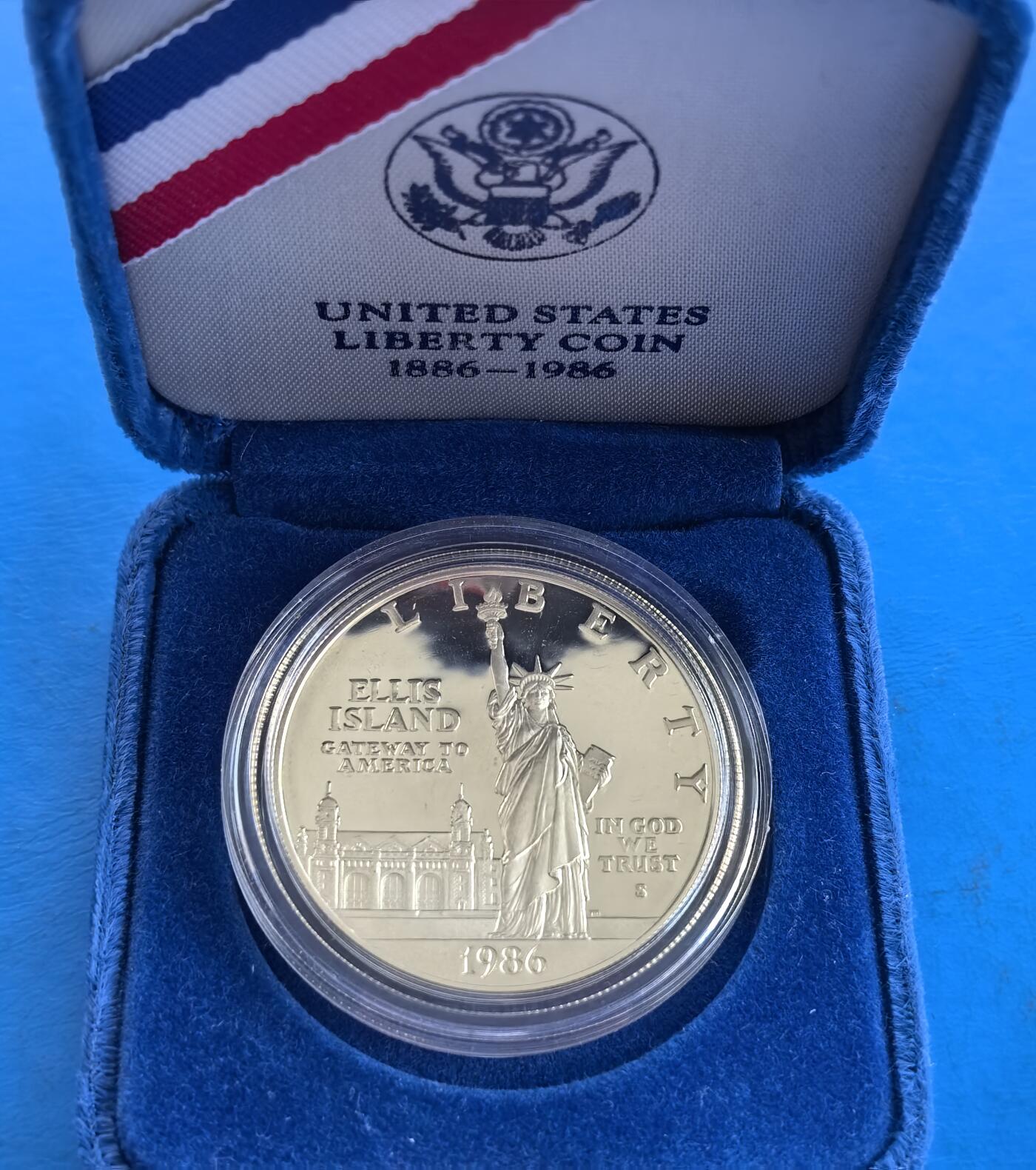 外国优质银币南亚香港苏联等专场，周六九点倒数截拍，满百包邮，持续收拍 美国1986 年自由女神像百年精制银币带原盒，正面是自由女神像与埃利斯岛移民大楼，象征美国移民历史；背面是火炬与《新巨人》诗句，兼具历史纪念意义与艺术收藏价值。