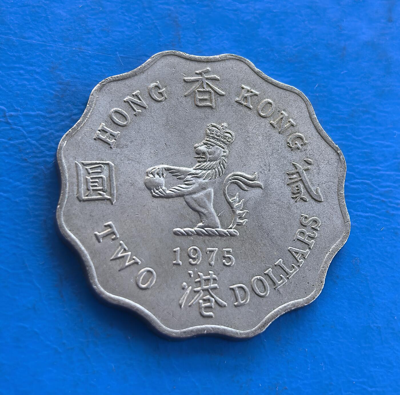 外国优质银币南亚香港苏联等专场，周六九点倒数截拍，满百包邮，持续收拍 原光1975年香港贰圆，正面为英女王伊丽莎白二世侧面像，环刻 “QUEEN ELIZABETH THE SECOND” 字样；背面是戴皇冠的狮子图案，搭配 “香港 贰圆” 字样与英文 “TWO DOLLARS”，采用独特的波浪花边设计。原光包浆保留出厂光泽，见证英属香港末期货币历史，是近代殖民钱币收藏的优质品类。