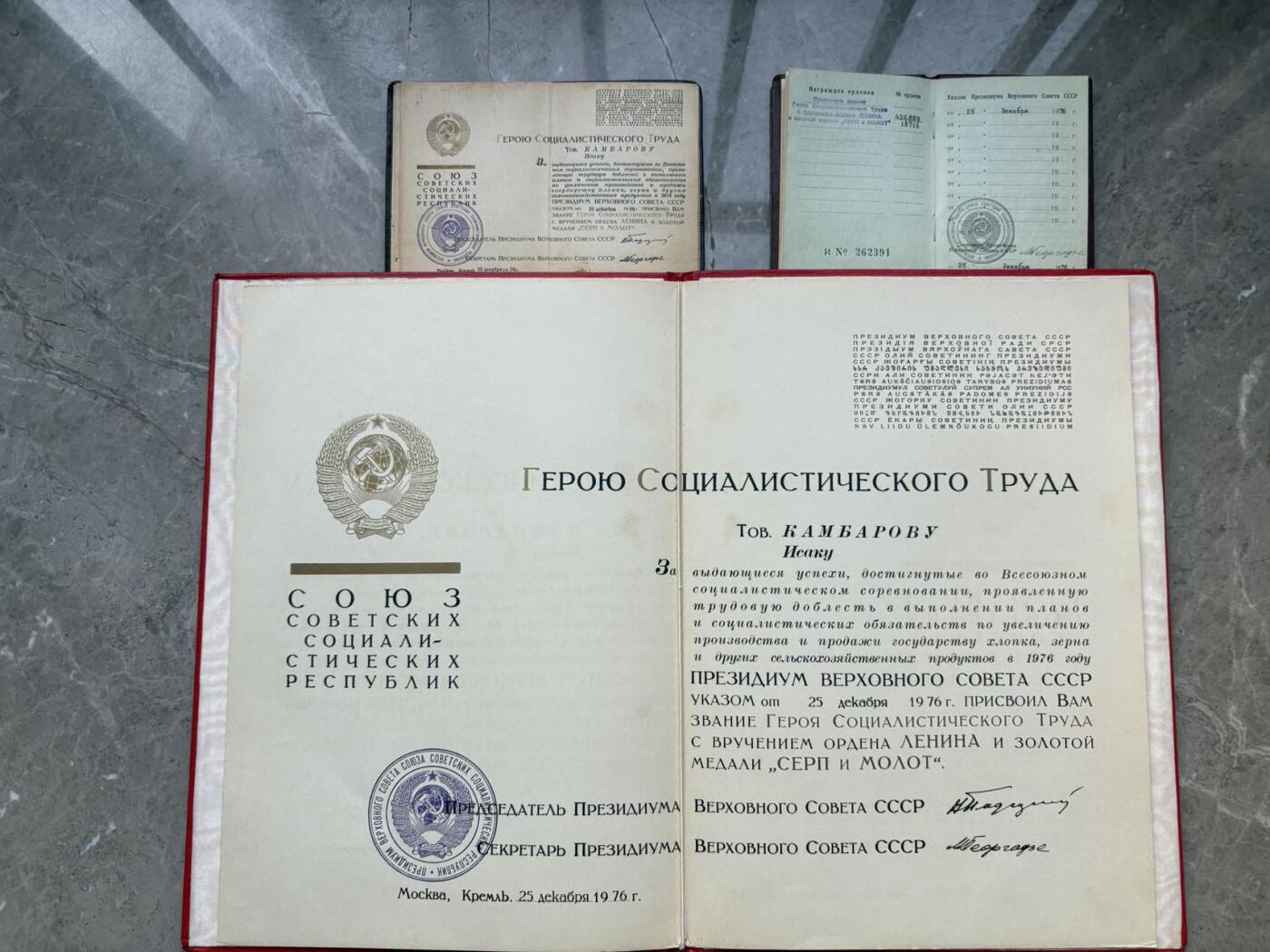 盛世勋华——号角文化勋章邮票专场拍卖第299期 苏联劳动英雄（小金星）大小证书一套三本，包括 1976年12月25日授予坎巴罗夫·伊萨克（乌兹别克棉花工头 1976年在数次完成打破棉花生产计划获得）小金星奖章编号：18716 尼古拉·波德戈尔尼签名 （这人数次打破棉花生产记录 估计和棉花案有关），苏联劳动英雄和列宁勋章证书 小金星奖章编号：18716 列宁勋章编号：426889 