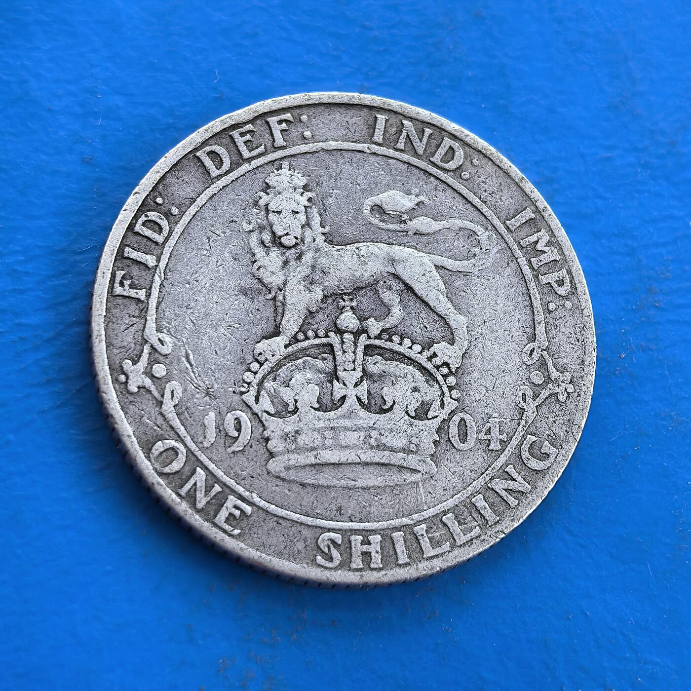外国优质银币南亚香港苏联等专场，周六九点倒数截拍，满百包邮，持续收拍 英国1904 年爱德华七世 1 先令银币，正面是国王侧面像，轮廓虽经磨损仍显威严；背面为皇冠雄狮浮雕，承载大英帝国历史印记，百年银质包浆温润厚重，兼具流通币的实用价值与历史收藏意义。