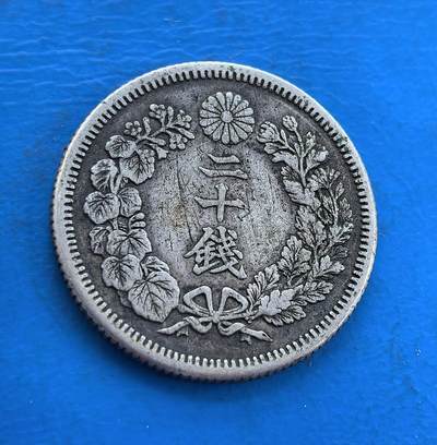 外国优质银币南亚香港苏联等专场，周六九点倒数截拍，满百包邮，持续收拍 - 日本明治四十二年二十钱银币，正面放射状旭日纹环以樱花，光芒饱满极具视觉张力；背面花叶环绕 “二十钱” 字样，纹饰细腻典雅，百年包浆温润自然，是兼具日式美学与历史价值的收藏佳品。