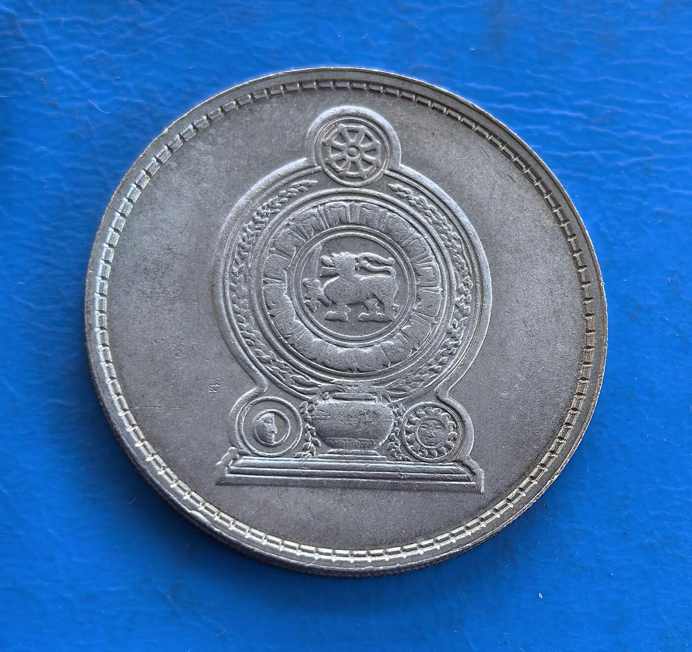 外国优质银币南亚香港苏联等专场，周六九点倒数截拍，满百包邮，持续收拍 斯里兰卡1978 年1 卢比纪念币，正面是前总统朱尼厄斯・理查德・贾亚瓦德纳的侧面像，辅以僧伽罗语、泰米尔语、英语三种文字，设计多元；背面是斯里兰卡国徽，展现佛教文化与国家象征，温润包浆沉淀着时代底蕴，是兼具历史意义与特色的收藏币种。