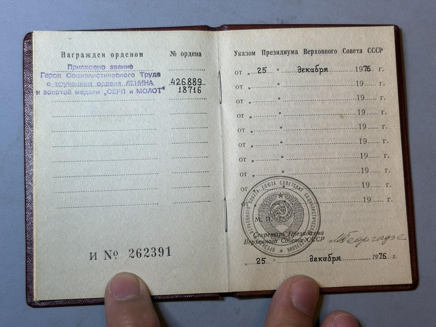 盛世勋华——号角文化勋章邮票专场拍卖第299期 苏联劳动英雄（小金星）大小证书一套三本，包括 1976年12月25日授予坎巴罗夫·伊萨克（乌兹别克棉花工头 1976年在数次完成打破棉花生产计划获得）小金星奖章编号：18716 尼古拉·波德戈尔尼签名 （这人数次打破棉花生产记录 估计和棉花案有关），苏联劳动英雄和列宁勋章证书 小金星奖章编号：18716 列宁勋章编号：426889 