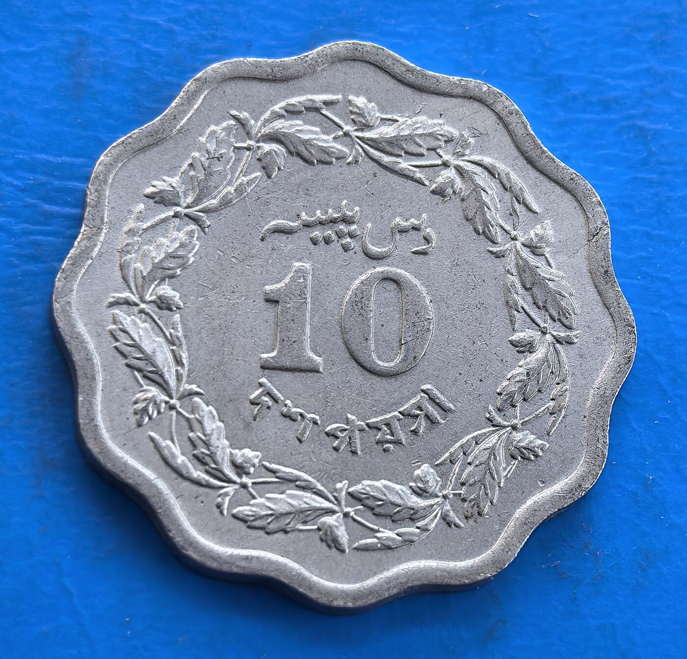 外国优质银币南亚香港苏联等专场，周六九点倒数截拍，满百包邮，持续收拍 巴基斯坦1971 年发行的 10 派沙流通币，采用独特的梅花形造型，正面是星月国徽与乌尔都语、孟加拉语文字，象征多元文化融合；背面是 “10” 面值与橄榄枝纹饰，寓意和平与发展，温润包浆沉淀着特殊历史时期的印记，是极具历史价值的收藏币种。