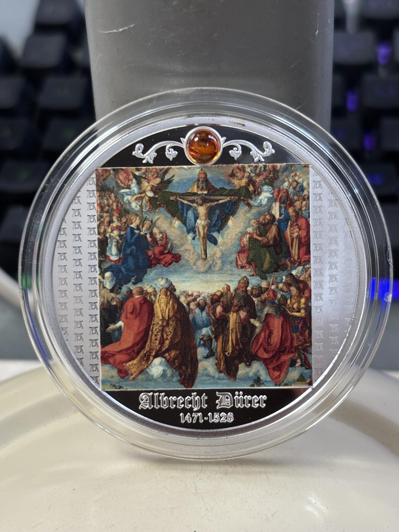 第188期拍卖 喀麦隆2021年丢勒名画三位一体崇拜镶嵌琥珀彩银币，999银，17.5克，发行550枚，塑料盒有碎