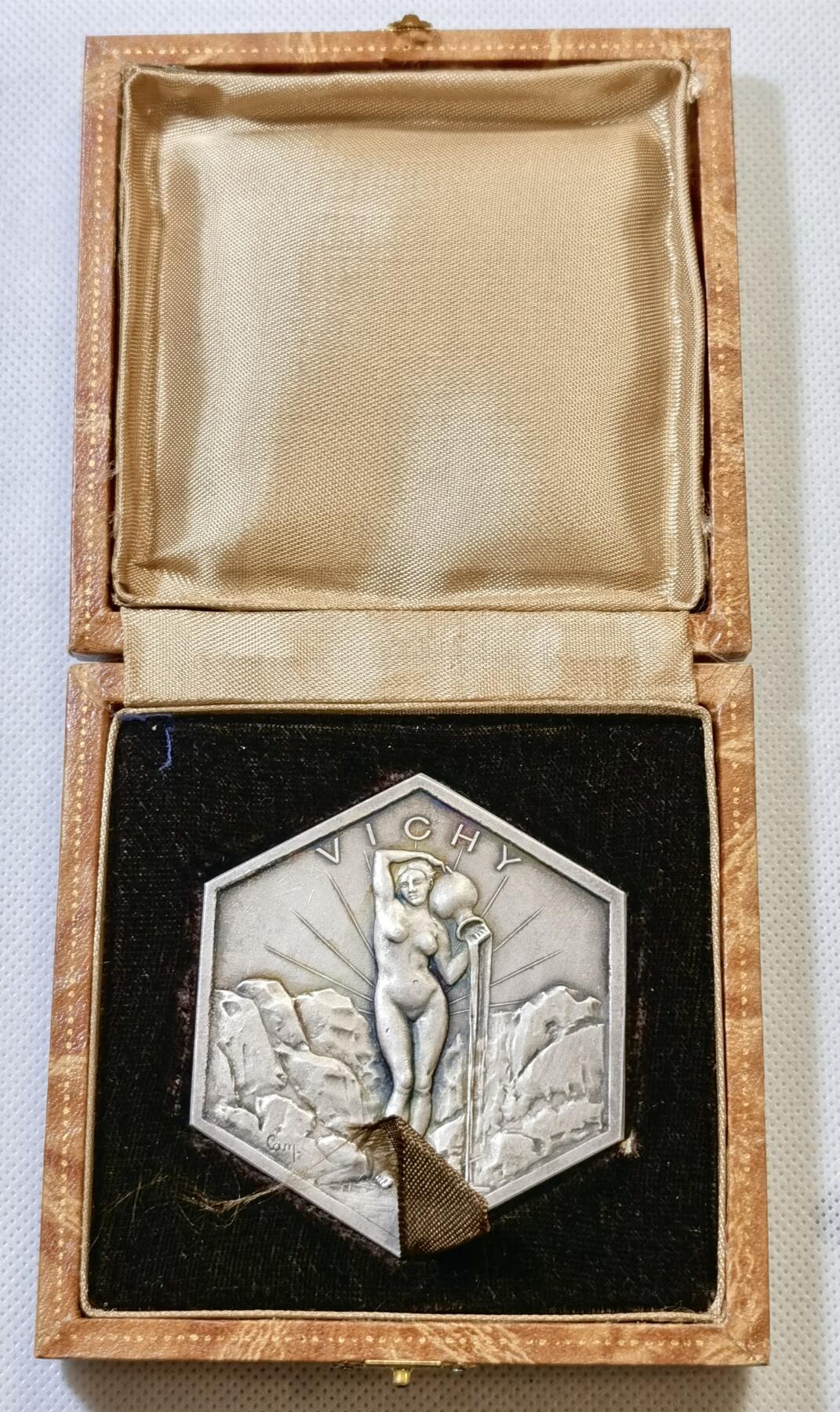 甄臻铺-世界币章拍卖（第48期）精品场拍品征集中，送拍享返佣金等优惠多多 法国山泉小镇纪念章，法国著名的山泉小镇维希市城市纪念章，雕刻画面是著名的古典油画《泉》。材质不明，可能是铜镀银或者银章，无边铭，直径61mm，重量98.4g，品相完美，有完好原盒，如图。