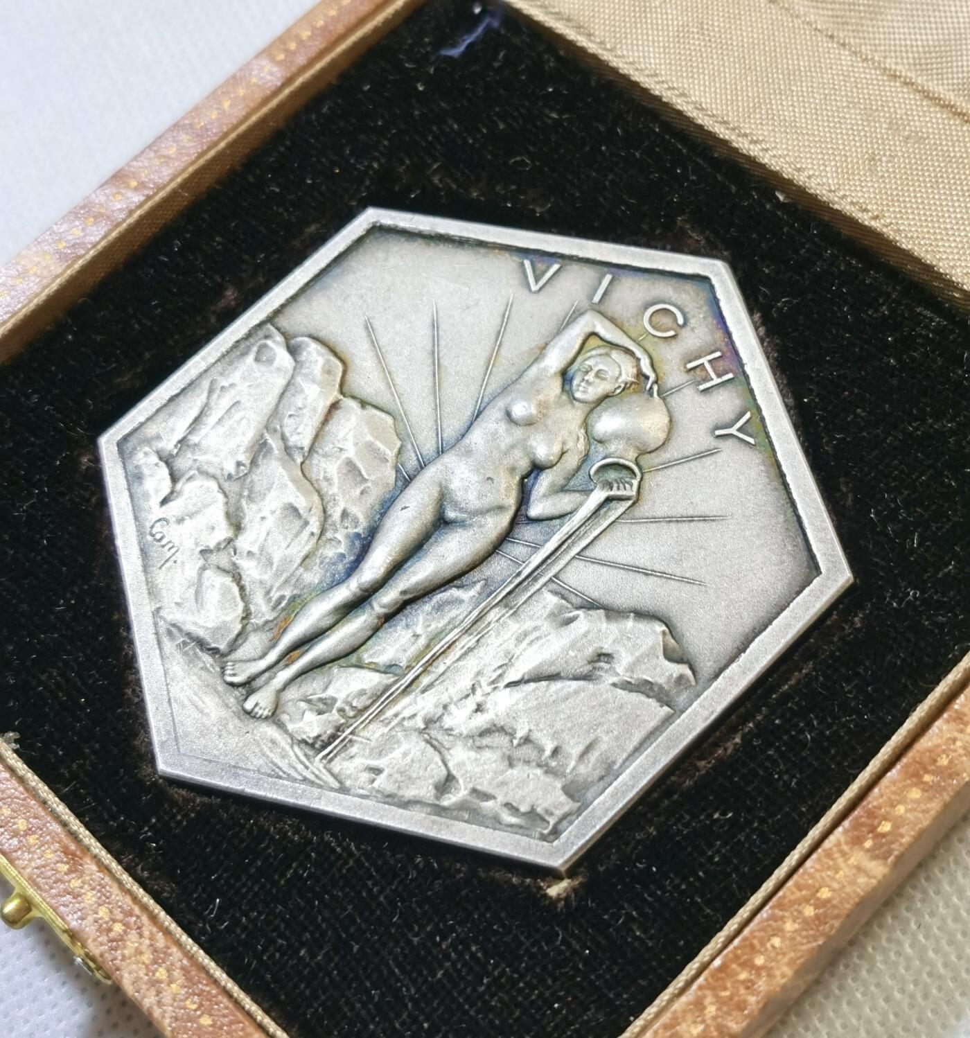 甄臻铺-世界币章拍卖（第48期）精品场拍品征集中，送拍享返佣金等优惠多多 法国山泉小镇纪念章，法国著名的山泉小镇维希市城市纪念章，雕刻画面是著名的古典油画《泉》。材质不明，可能是铜镀银或者银章，无边铭，直径61mm，重量98.4g，品相完美，有完好原盒，如图。