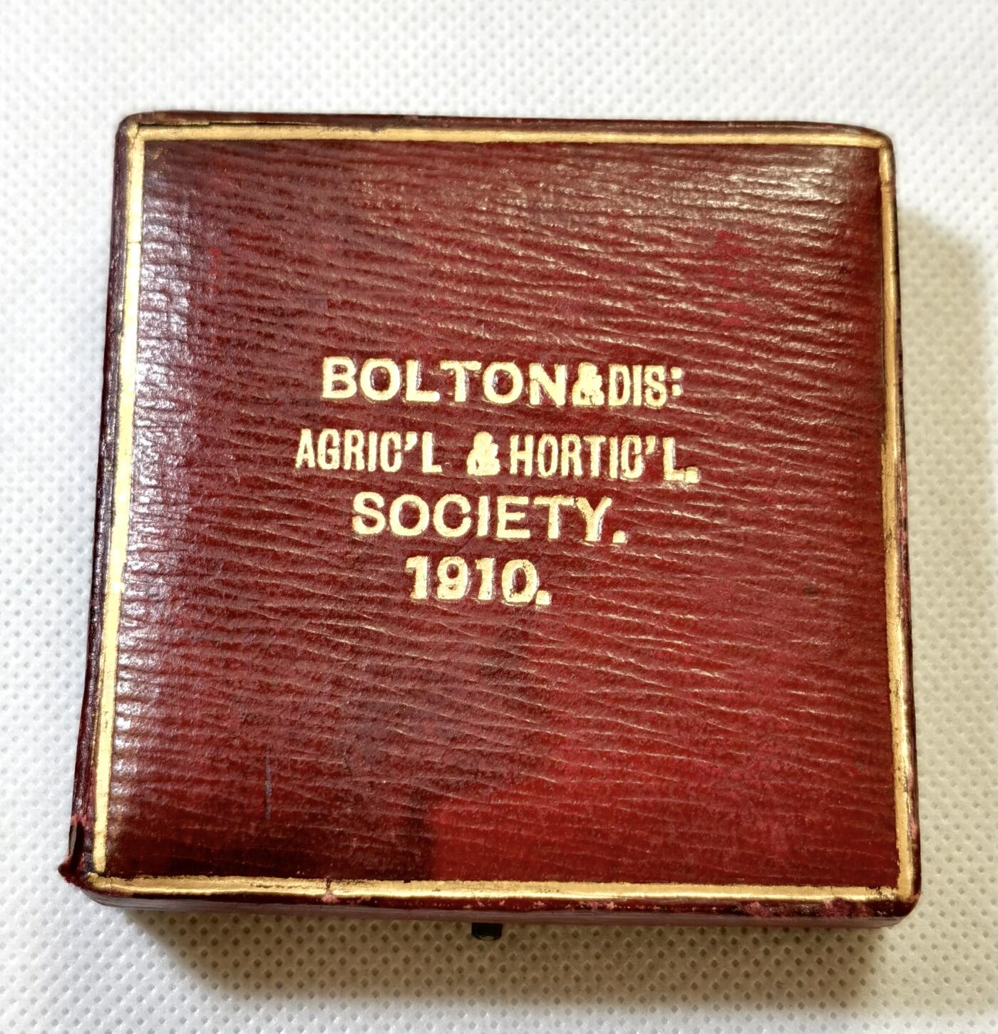 甄臻铺-世界币章拍卖（第48期）精品场拍品征集中，送拍享返佣金等优惠多多 1910年英国Bolton & District Agricultural & Horticultural Society农业园艺协会颁发的银质奖章，直径51.5毫米，重56.8克，带原装红皮盒。奖章正面刻有协会名称、建筑、牛马等农业元素，背面环绕麦穗花环，中心有双头鹰图案，细节丰富，工艺精致。