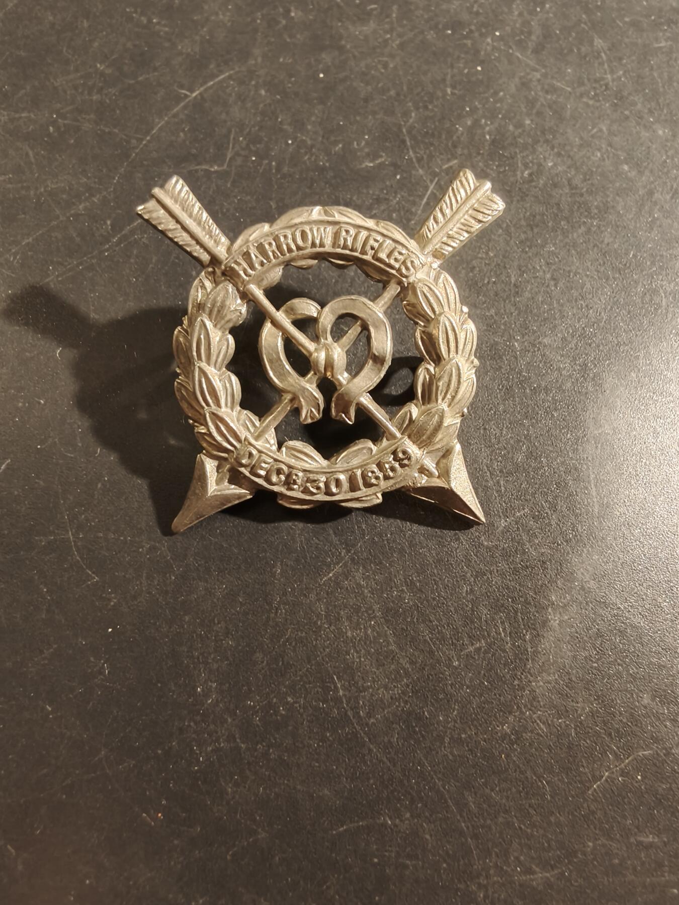 老王徽章第177期 英国哈罗步枪队帽徽     一战时期    哈罗步枪队于1860年成立，是当时英国各地为应对法国潜在威胁而兴起的志愿军运动的一部分。最初的哈罗步枪队后来并入了同名的著名公学——哈罗公学（Harrow School）的学生军团。