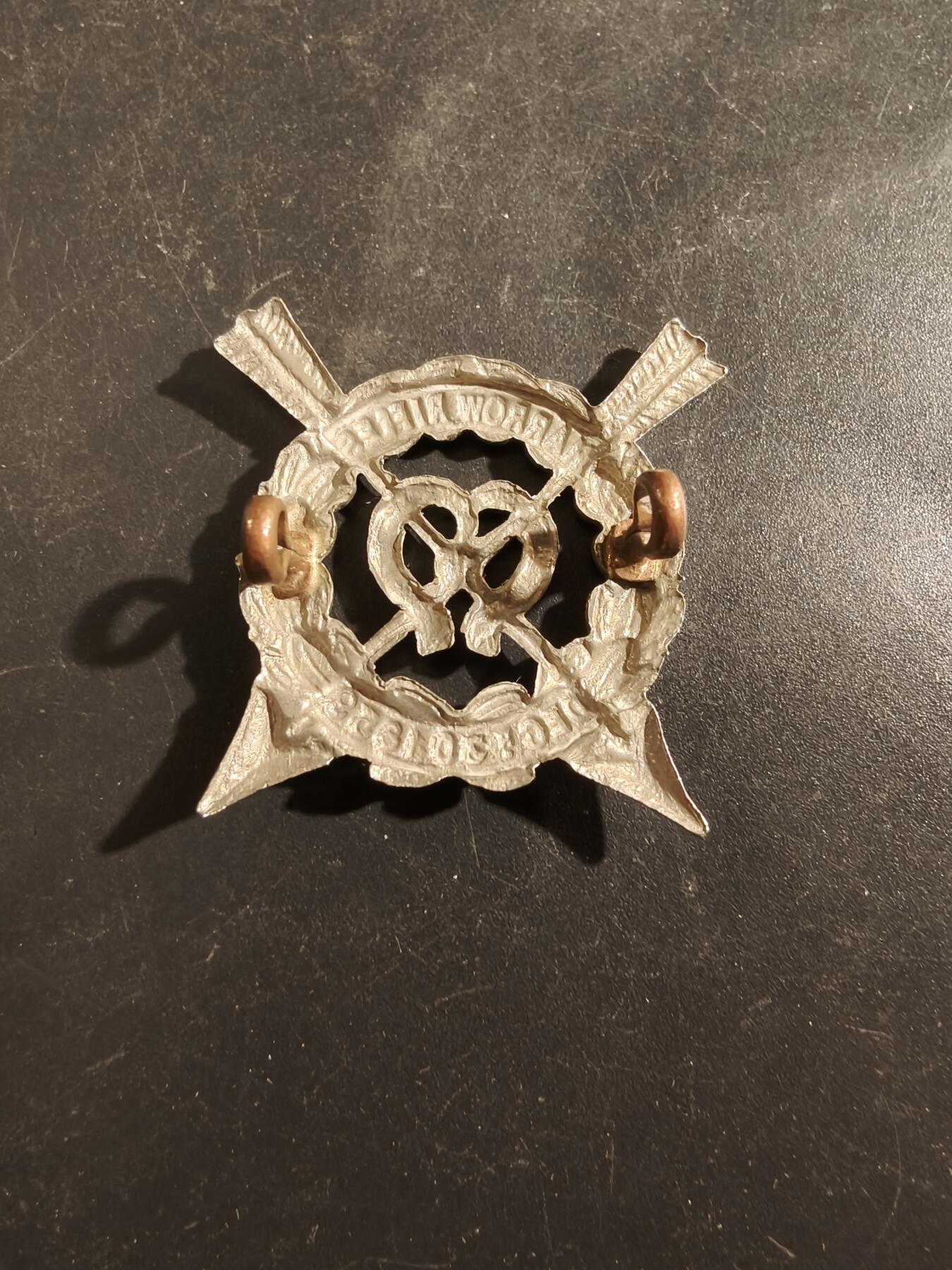 老王徽章第177期 英国哈罗步枪队帽徽     一战时期    哈罗步枪队于1860年成立，是当时英国各地为应对法国潜在威胁而兴起的志愿军运动的一部分。最初的哈罗步枪队后来并入了同名的著名公学——哈罗公学（Harrow School）的学生军团。