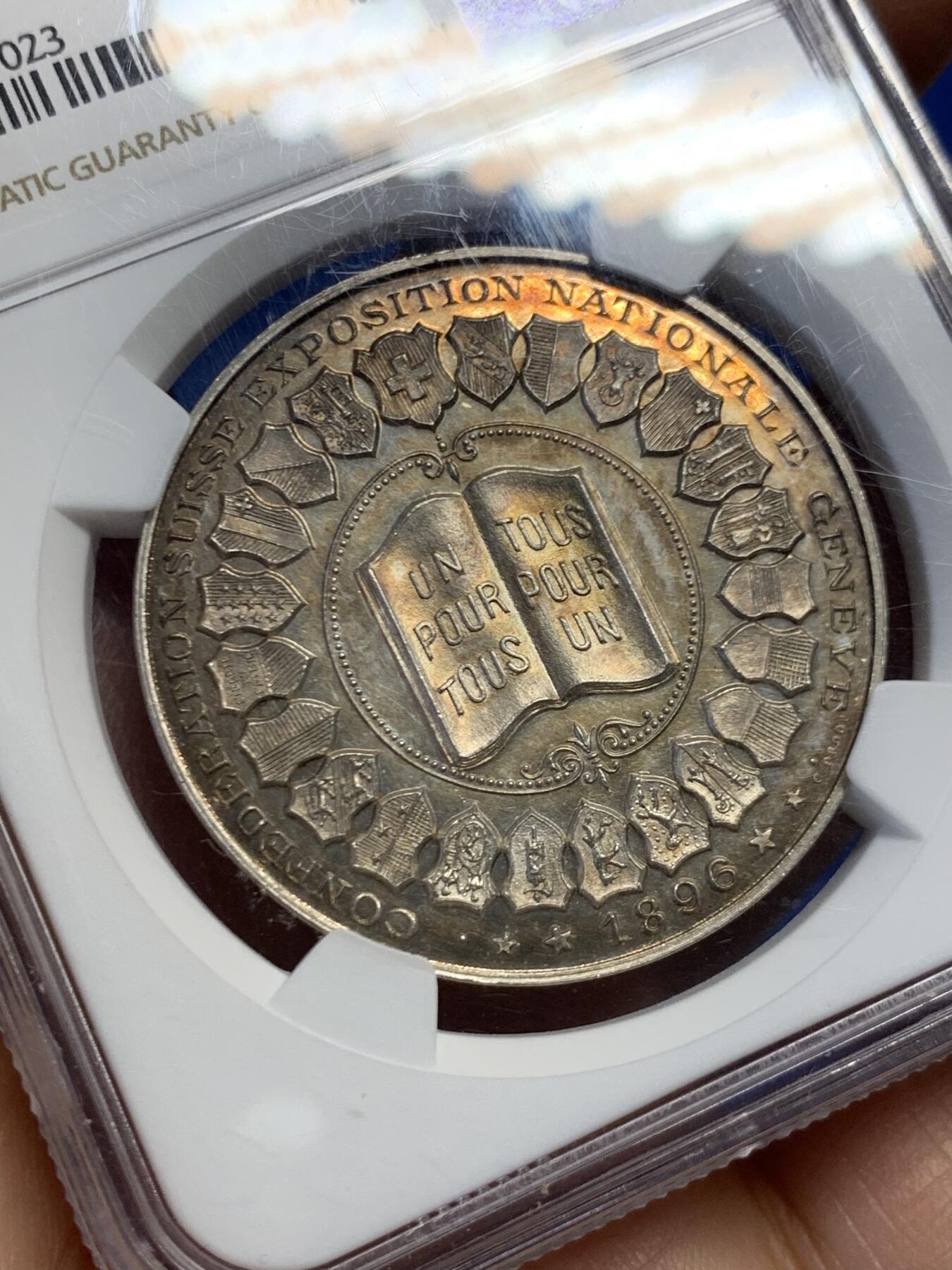 《竞宝斋》第459场 周日，周一，2场连拍 （全场包邮）欢迎送拍 NGC MS63 1896年瑞士联邦博览会银章，正面为参展的22个州盾徽，背面为博览会主建筑美术宫大门，正反黄昏金彩包浆，工艺精湛、雕刻精细，罕见品种。