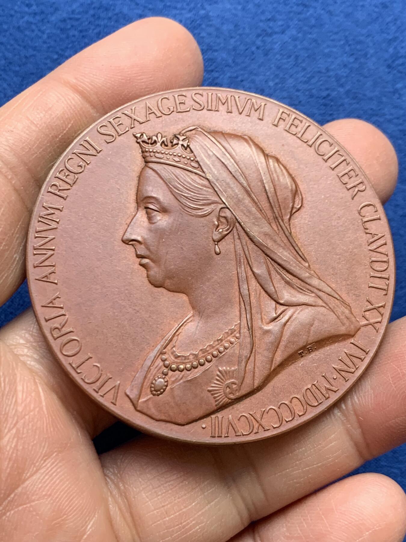 《竞宝斋》第459场 周日，周一，2场连拍 （全场包邮）欢迎送拍 英国1897年皇家造币厂铸造的维多利亚女王登基60周年钻石禧年纪念铜章，章面由乔治·威廉·德索尔斯设计，正面为维多利亚女王老年披纱侧面像，环刻拉丁铭文记录登基60周年纪年；背面为女王青年时期侧面像，搭配《箴言》经典语句，浮雕层次分明，铜质氧化包浆自然，极好地呈现了维多利亚时代造币工艺水准。76.55克，55.3mm，带原盒。