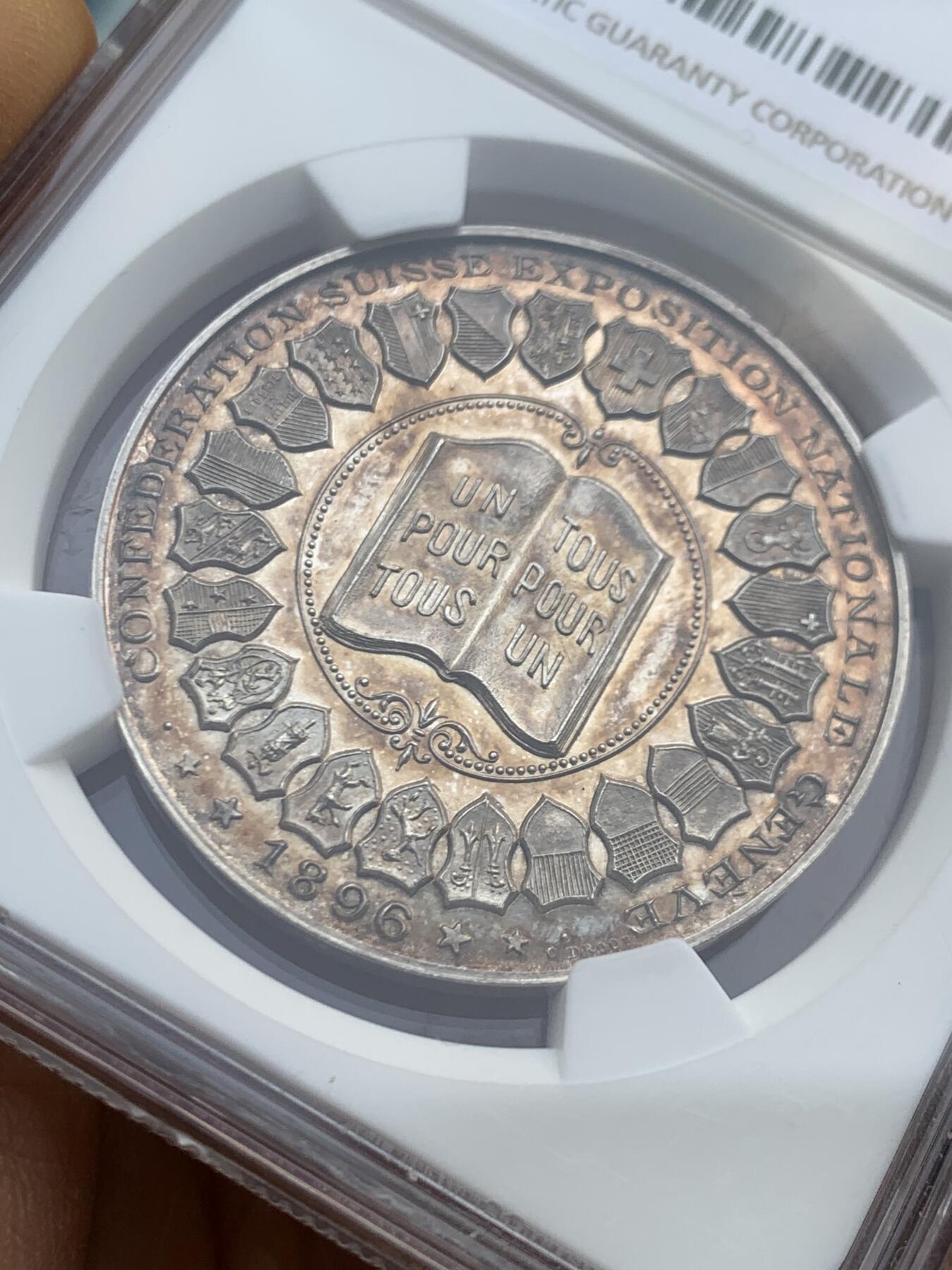 《竞宝斋》第459场 周日，周一，2场连拍 （全场包邮）欢迎送拍 NGC MS63 1896年瑞士联邦博览会银章，正面为参展的22个州盾徽，背面为博览会主建筑美术宫大门，正反黄昏金彩包浆，工艺精湛、雕刻精细，罕见品种。