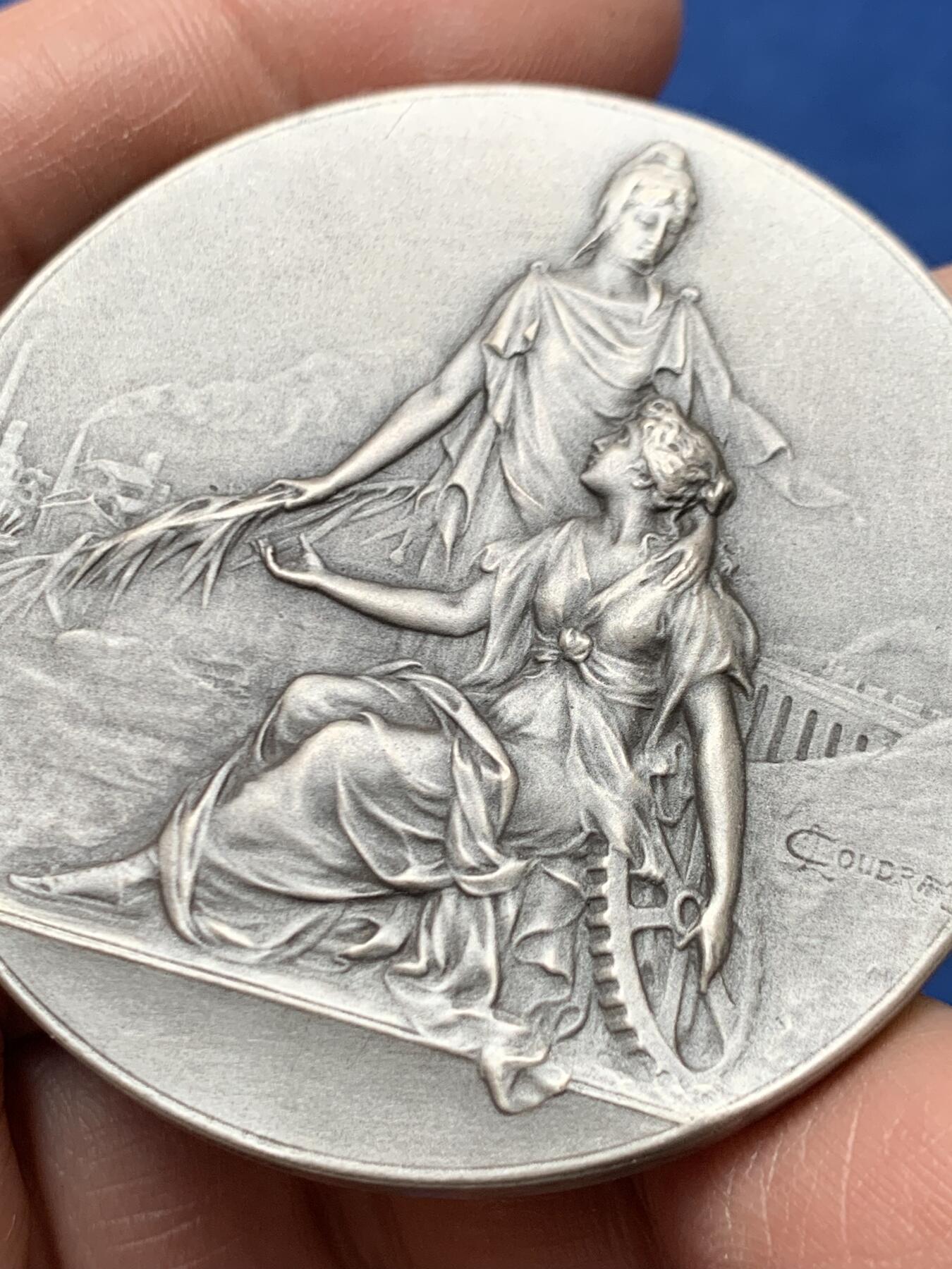 《竞宝斋》第460场 周日，周一，2场连拍 （全场包邮）欢迎送拍 法国1954年鲁昂市建筑业总工会镀银铜章，品相佳。直径50mm，重60.5g，丰饶角铜标。Coudray经典作品，刻画的是:玛丽安娜女神把棕榈枝送给抱着齿轮、代表着工业的女子，浪漫飘逸的新艺术风格作品。