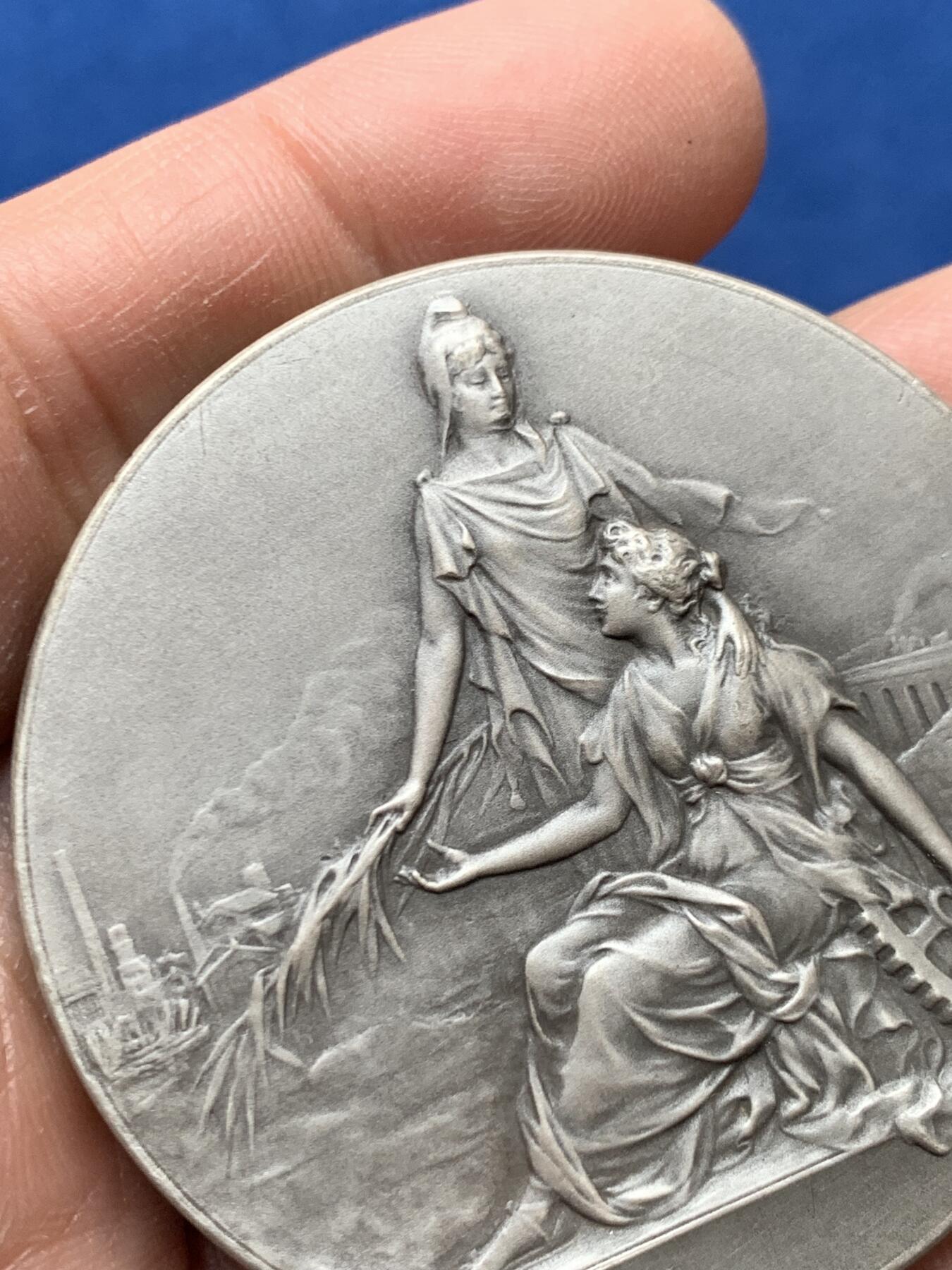 《竞宝斋》第460场 周日，周一，2场连拍 （全场包邮）欢迎送拍 法国1954年鲁昂市建筑业总工会镀银铜章，品相佳。直径50mm，重60.5g，丰饶角铜标。Coudray经典作品，刻画的是:玛丽安娜女神把棕榈枝送给抱着齿轮、代表着工业的女子，浪漫飘逸的新艺术风格作品。