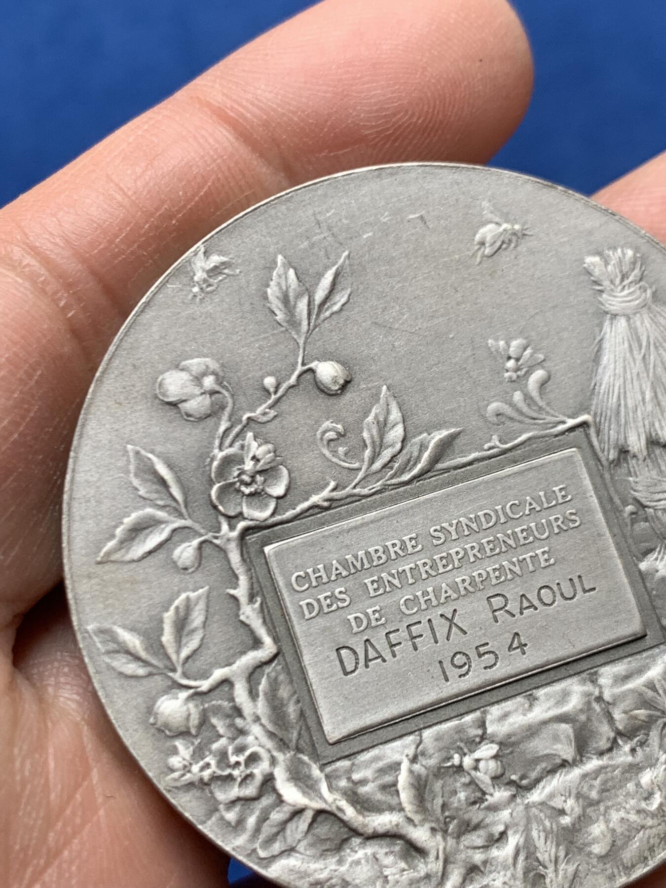 《竞宝斋》第460场 周日，周一，2场连拍 （全场包邮）欢迎送拍 法国1954年鲁昂市建筑业总工会镀银铜章，品相佳。直径50mm，重60.5g，丰饶角铜标。Coudray经典作品，刻画的是:玛丽安娜女神把棕榈枝送给抱着齿轮、代表着工业的女子，浪漫飘逸的新艺术风格作品。