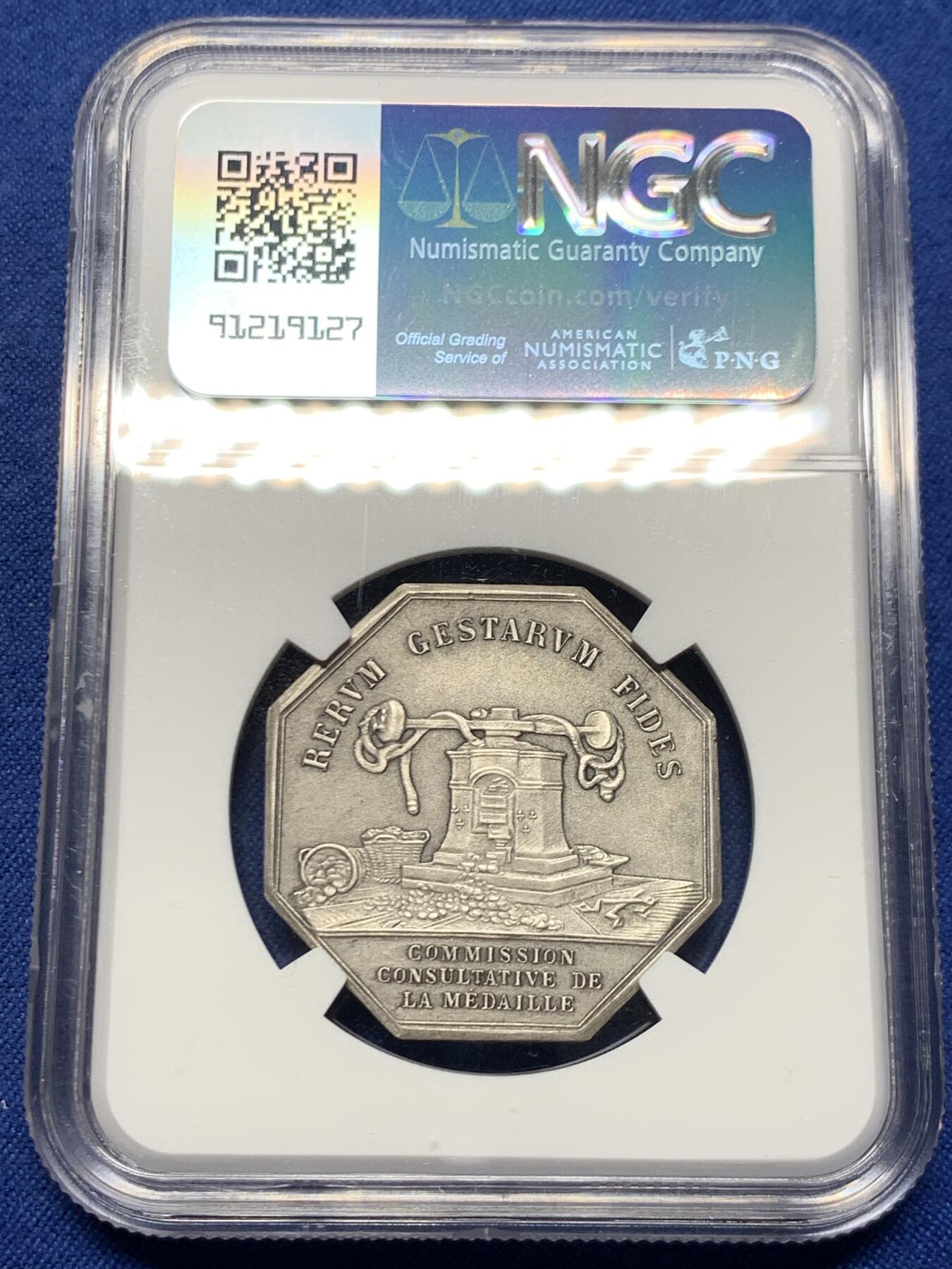 《竞宝斋》第460场 周日，周一，2场连拍 （全场包邮）欢迎送拍 NGC MS63 法国八角镀银铜质代币，正面雕刻一位羽翼女神(胜利或命运女神)牵引着小天使(爱神丘比特)，象征着命运引导下的爱与希望，左侧为撒落的丰收之角(Cornucopia)，右下角有艺术家名“DE PUYMAURIN”与雕刻标记，与整体构图共同形成寓言式场景。