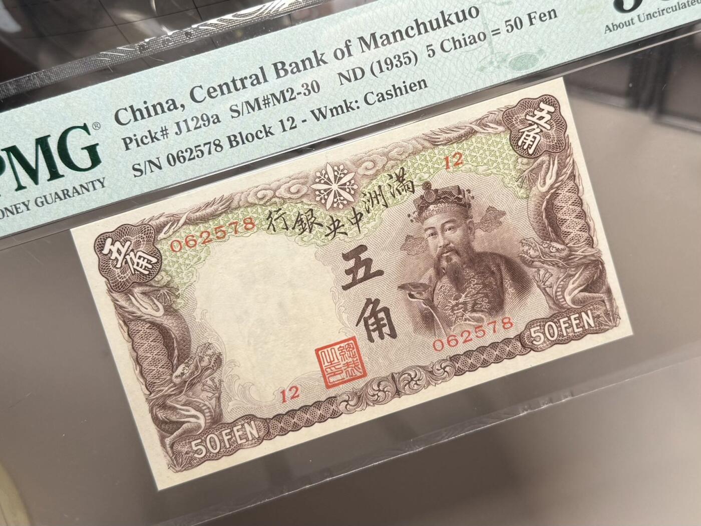 （自动截拍）PMG评级民国纸币专拍第20260126期，全场包邮 【乾奕收藏】出民国24年1935年满洲中央银行财神爷五角，早期乙号券版本背单线券，相比常见绿财神数量上更少，棕色财神图案，美国PMG50分