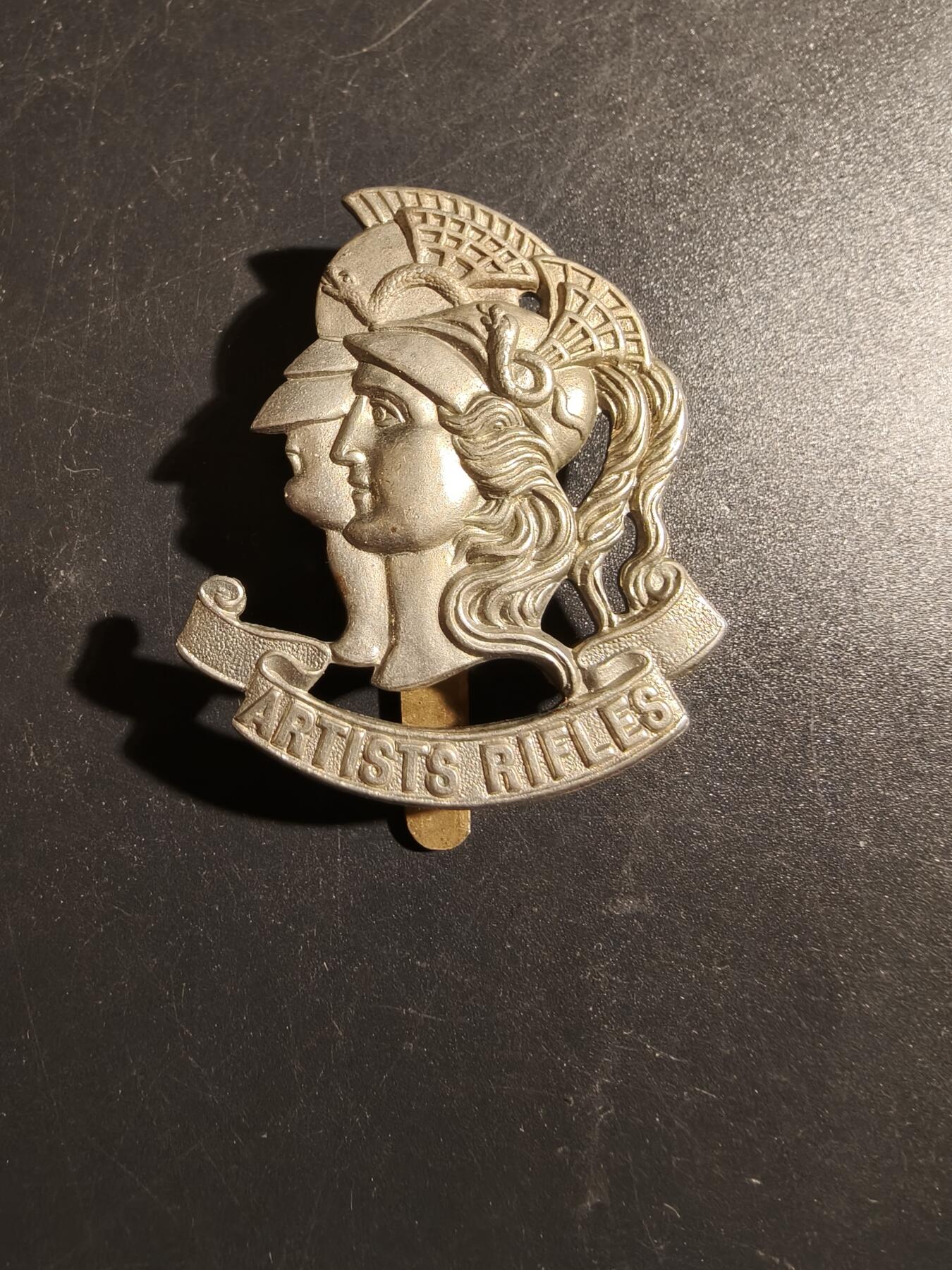 老王徽章第178期 英国陆军艺术家步枪团帽徽    一战时期     该团于1860年由一群画家、雕塑家、建筑师、音乐家和作家组成，最初是志愿步枪队，二战后，该团于1947年改组为英国特种空勤团 (SAS) 的一部分，即第21特别空勤团 (Artists Rifles)。