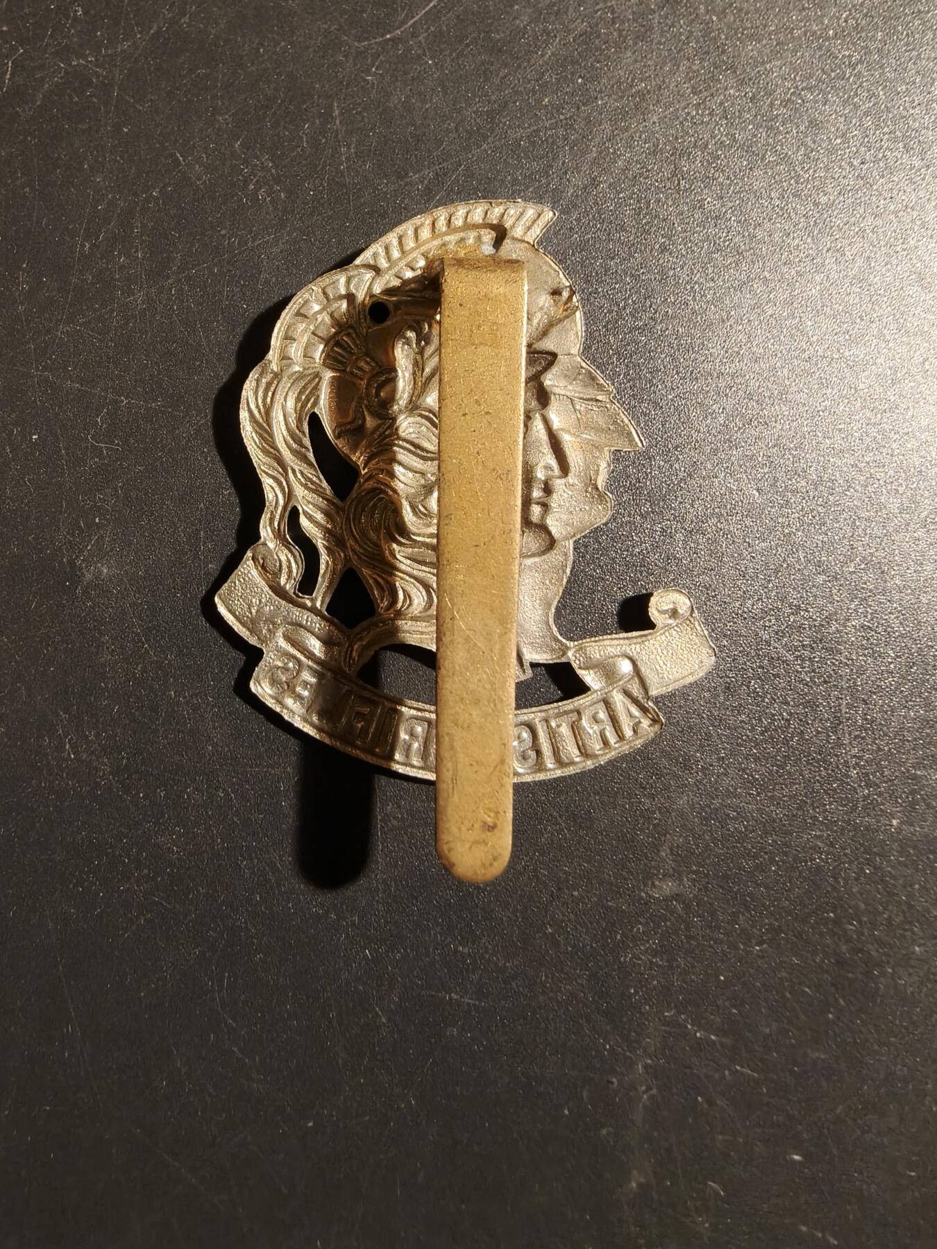 老王徽章第178期 英国陆军艺术家步枪团帽徽    一战时期     该团于1860年由一群画家、雕塑家、建筑师、音乐家和作家组成，最初是志愿步枪队，二战后，该团于1947年改组为英国特种空勤团 (SAS) 的一部分，即第21特别空勤团 (Artists Rifles)。