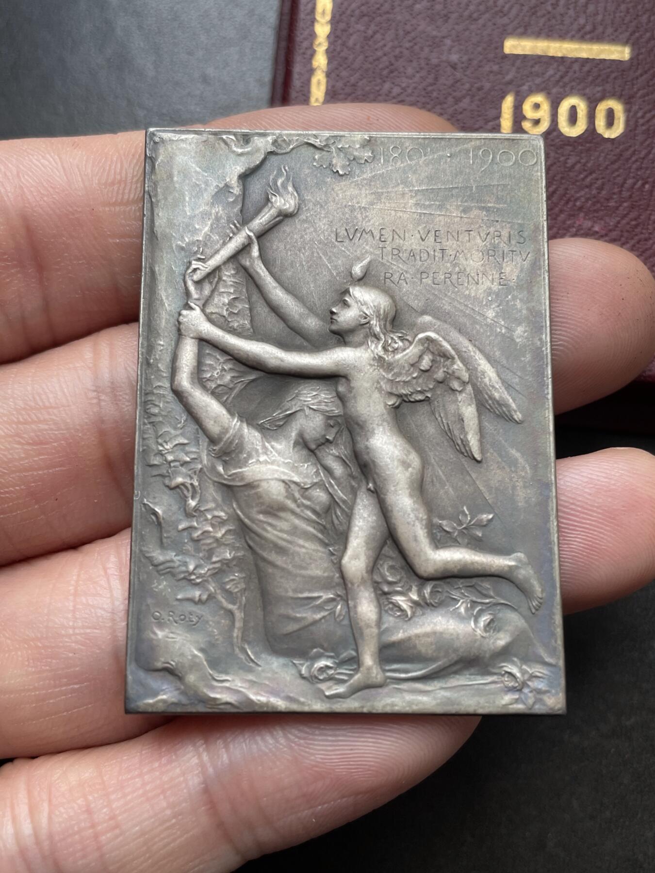 「木头集藏」章牌精品专场！ O.Roty～1900年法国世纪之交原盒镀银铜章，尺寸: 51 x 36 mm， 边铭: 丰饶角 BRONZE ，少见原盒正常使用，同款收藏佳品！正面青少的小天使象征着新世纪，昏睡过去的女子代表着十九世纪，天使垫着脚从女子手中取出熊熊燃烧的火炬寓意着新旧世纪的交接!