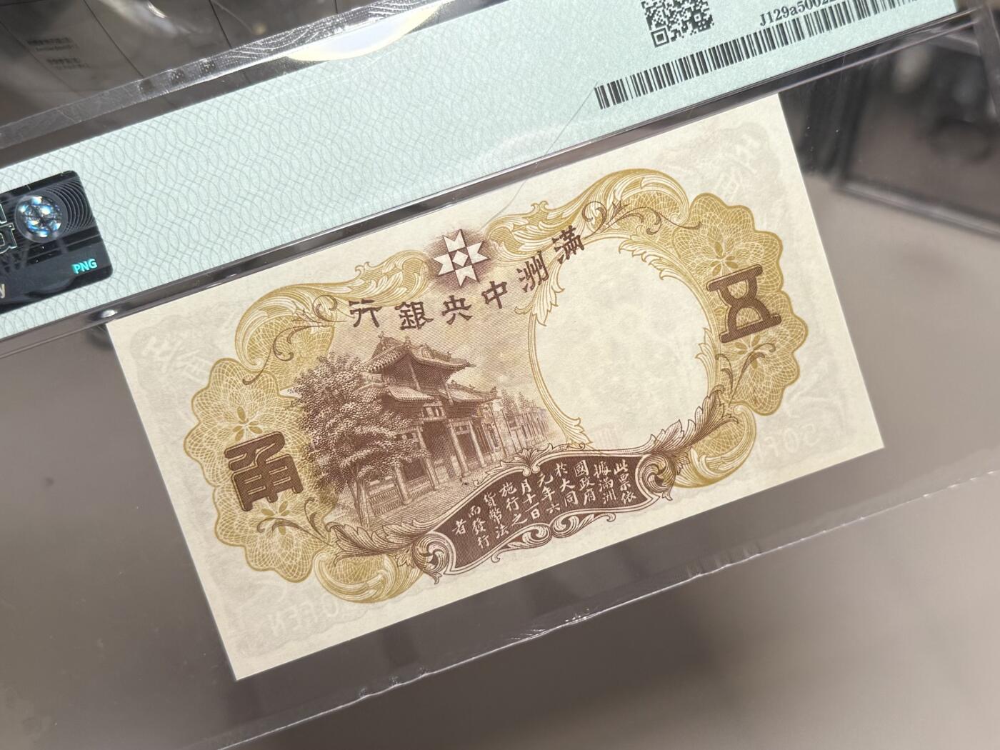 【乾奕收藏】出民国24年1935年满洲中央银行财神爷五角，早期乙号券版本背单线券，相比常见绿财神数量上更少，棕色财神图案，美国PMG50分，民国纸币经过80年能保存如此品相实属难得，喜欢的老板不要错过，评级币一切以分数为准，售出非假不退
