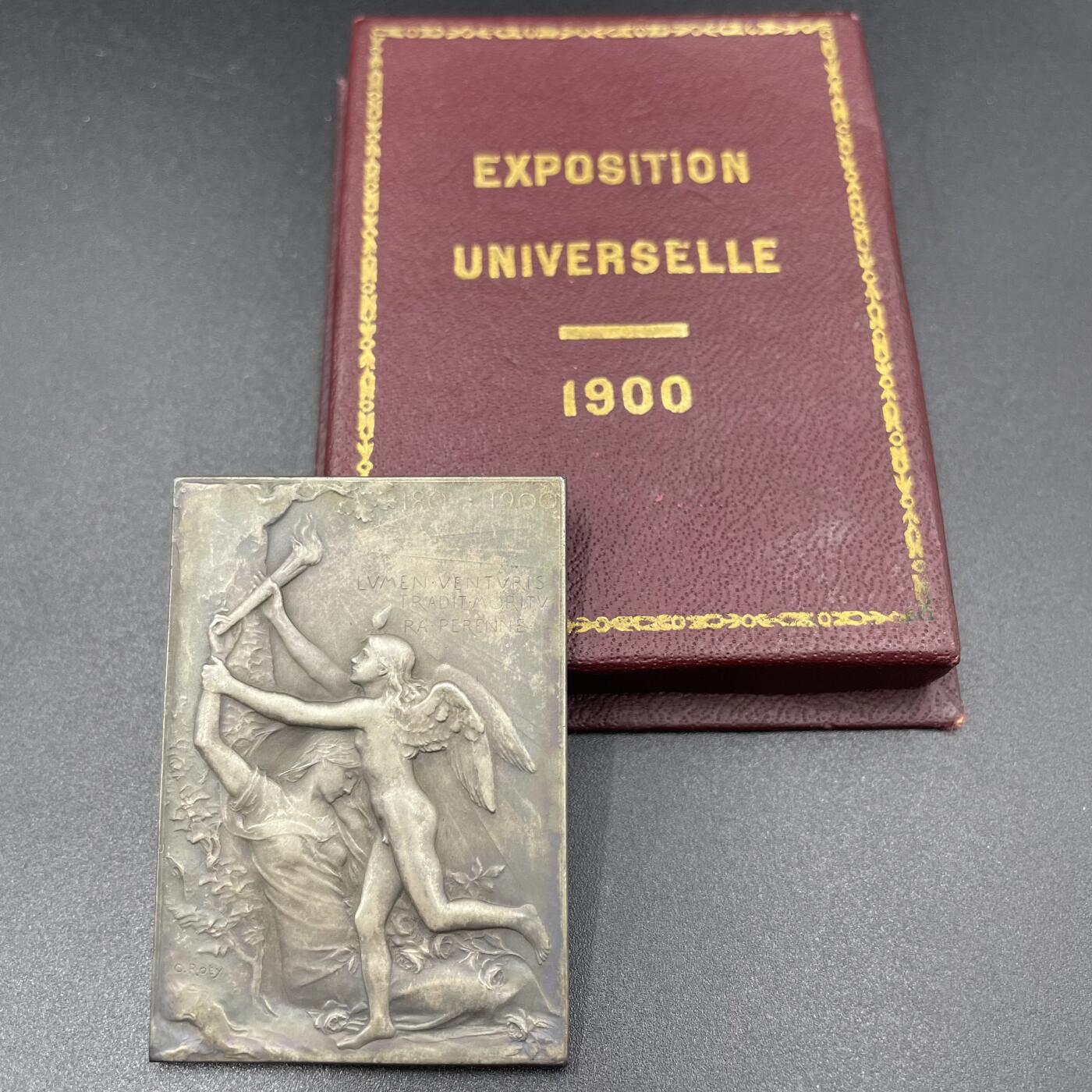 「木头集藏」章牌精品专场！ O.Roty～1900年法国世纪之交原盒镀银铜章，尺寸: 51 x 36 mm， 边铭: 丰饶角 BRONZE ，少见原盒正常使用，同款收藏佳品！正面青少的小天使象征着新世纪，昏睡过去的女子代表着十九世纪，天使垫着脚从女子手中取出熊熊燃烧的火炬寓意着新旧世纪的交接!