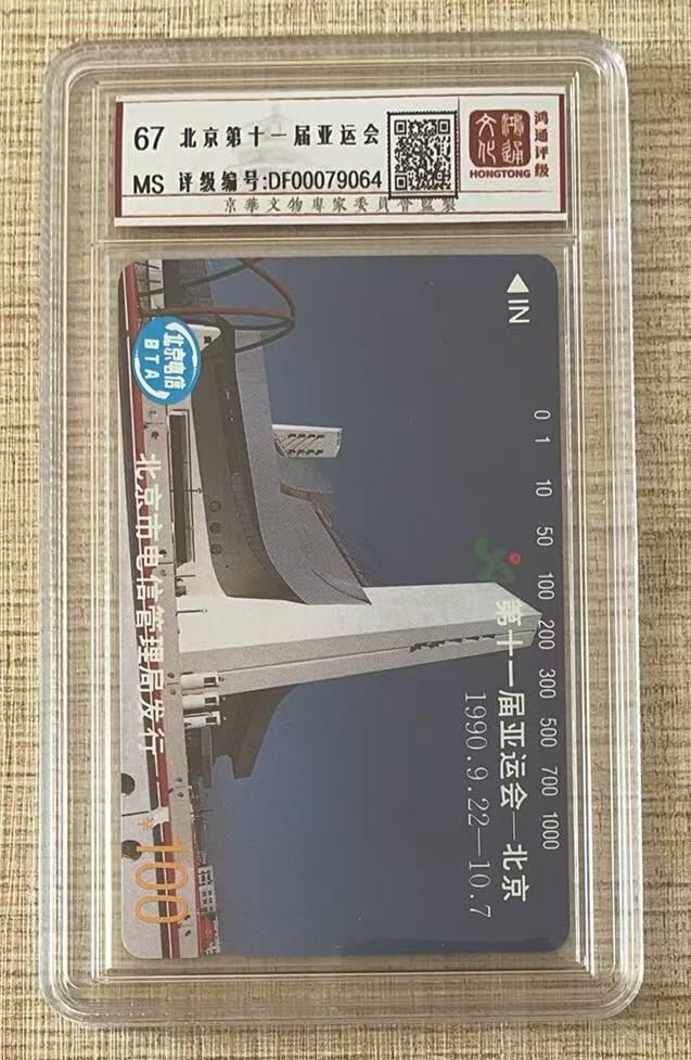 《卡拍》第343期拍卖1月24日晚22：10时延时截拍 北京田村卡《亚运会场馆100元面值》一枚新卡，鸿通盒装评级MS67分。