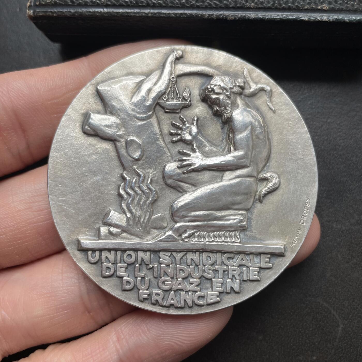 「木头集藏」章牌精品专场！ H Dropsy～1929年法国天然气工业联合会原盒银章 ，直径：64 mm，84 g，边铭：菱形厂标 ARGENT 野猪头银标。正面是一个潘神在用木柴取暖，背面是储存天然气的贮气罐。  少见的银章品种，1929年也是此章铸造的最早期年份之一。正面浮雕很高，很有雕塑的感觉。烫金字原盒状态良好。   