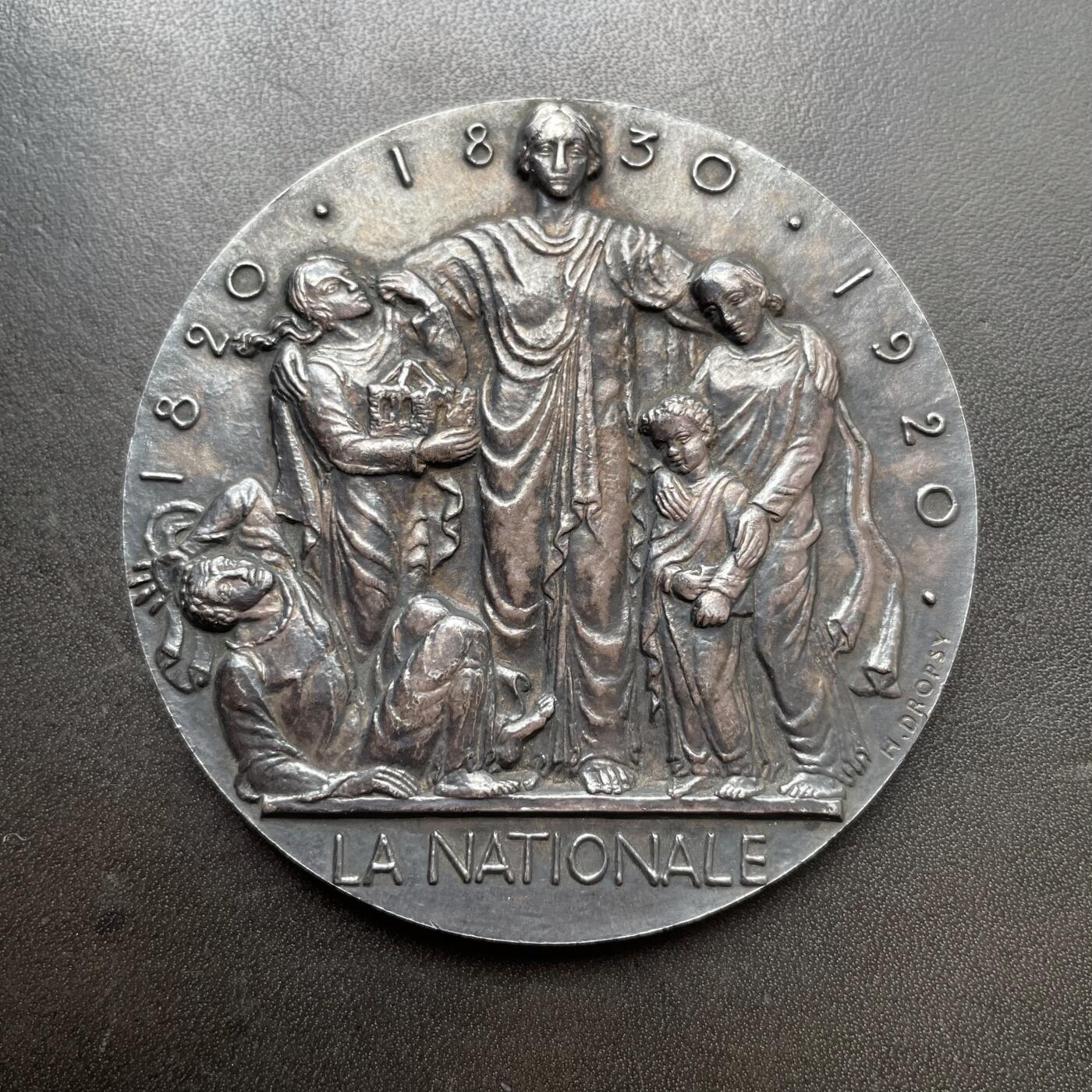 「木头集藏」章牌精品专场！ H. Dropsy～法国国家保险公司大银章 ，直径：70mm，189 g，边铭：菱形厂标+厂名V. CANALE ARGENT 野猪头银标。罕见品种！法国章牌名厂卡纳勒（V Canale）铸造。正面是保险公司化身的女神将老弱妇孺置于自己的庇护之下。法国国家保险公司的前身是1820年成立的皇家人寿保险公司，后重组改为此名。1968年与太阳保险公司和老鹰保险公司合并成为法国国家保险集团。