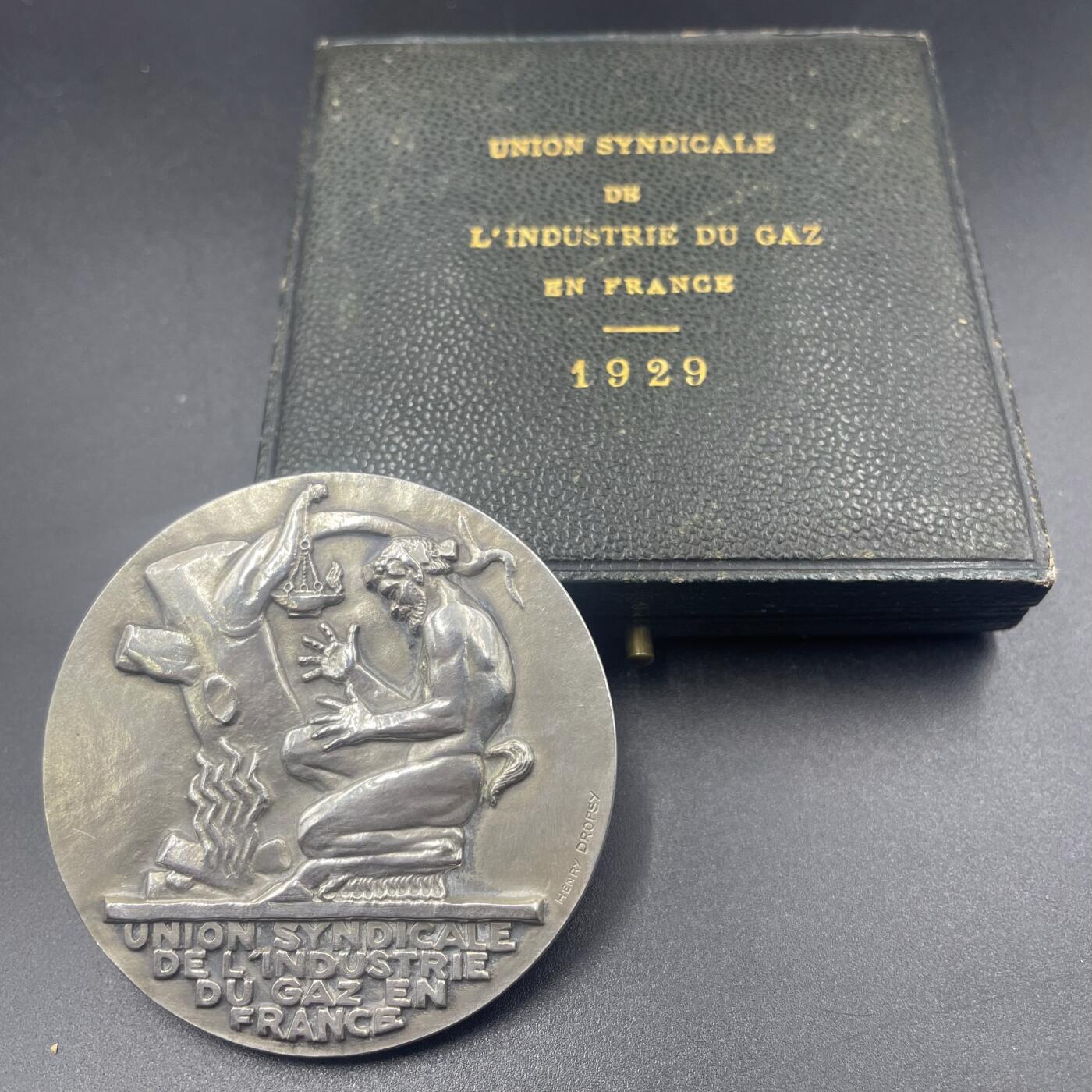 「木头集藏」章牌精品专场！ H Dropsy～1929年法国天然气工业联合会原盒银章 ，直径：64 mm，84 g，边铭：菱形厂标 ARGENT 野猪头银标。正面是一个潘神在用木柴取暖，背面是储存天然气的贮气罐。  少见的银章品种，1929年也是此章铸造的最早期年份之一。正面浮雕很高，很有雕塑的感觉。烫金字原盒状态良好。   