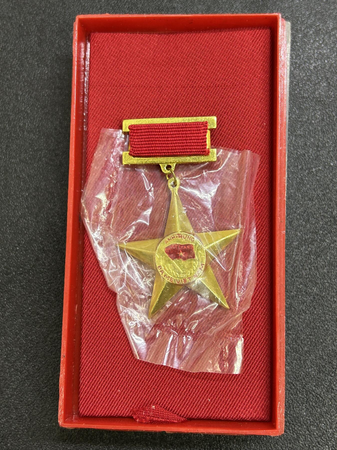 西秦中古拍卖第七十三期 越南英雄母亲勋章 母亲金星章 第一版带原盒 1994年9月10日设立，英雄越南母亲是越南国家授予或追授的荣誉称号，表彰那些为民族解放事业、保卫祖国和履行国际义务做出贡献和牺牲的越南妇女。因为她们的丈夫或者孩子都是战争伤残人员和烈士。