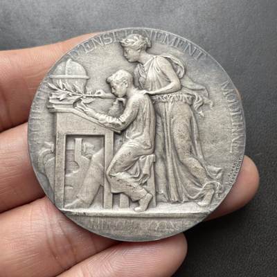 「木头集藏」章牌精品专场！ - Albert Herbemont～法国现代教育协会银章 ，直径：50 mm，64 g，边铭：丰饶角 1ARGENT。少见的银章品种。正面女神把橄榄枝放在学生的书桌上，背面旭日东升，橡树枝繁叶茂。表面采用磨砂工艺，有一些氧化形成的深色纹路，不是划痕，实物品相很好。