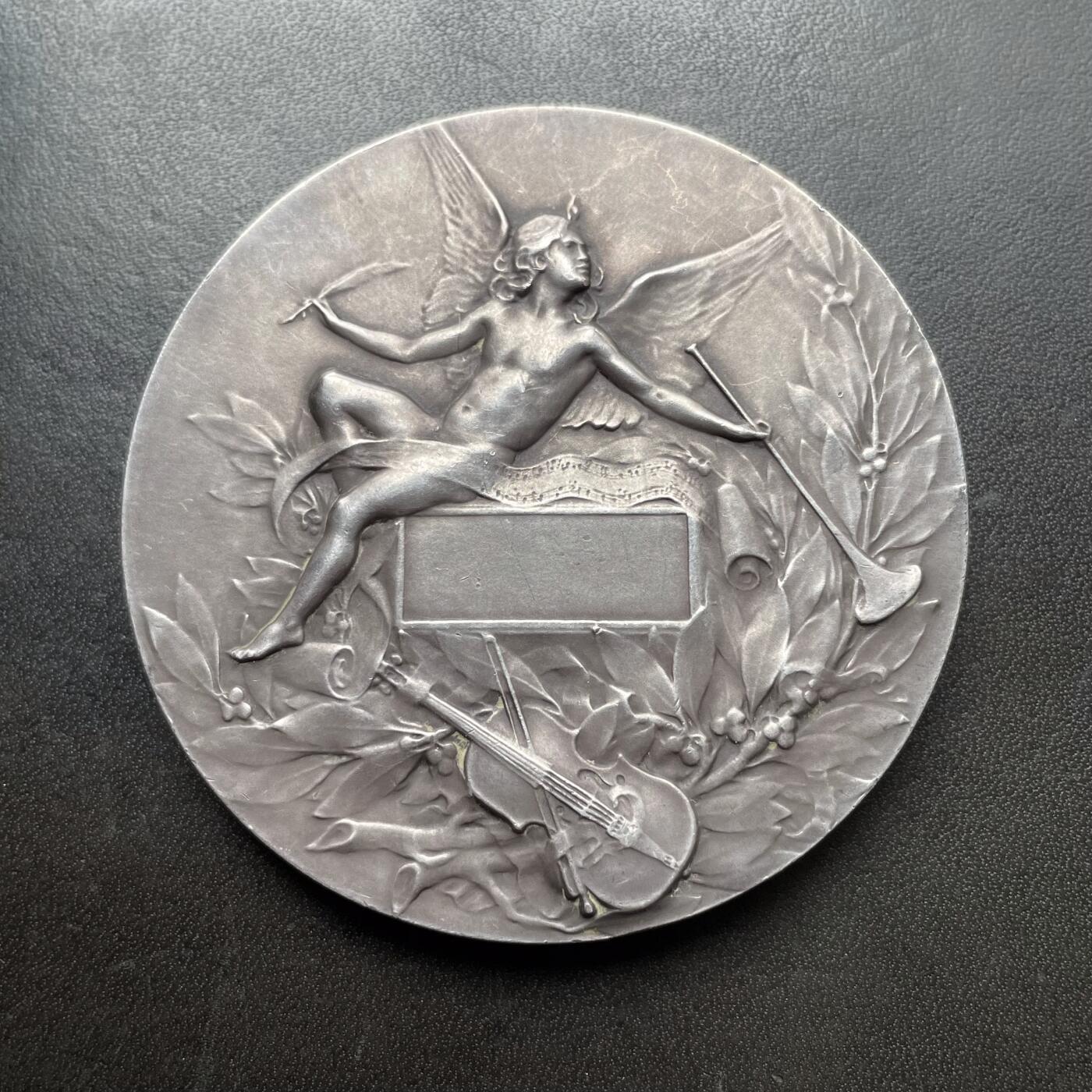 「木头集藏」章牌精品专场！ L.Coudray～法国音乐之神俄尔普斯大银章，直径：68 mm，162.3 g，边铭：丰饶角 ARGENT，名家高浮雕刻画作品，品相不错。俄耳甫斯，是古希腊神话中最著名的音乐家、诗人与先知，以超凡的音乐天赋和悲剧爱情闻名，太阳神阿波罗与缪斯女神卡利俄珀之子